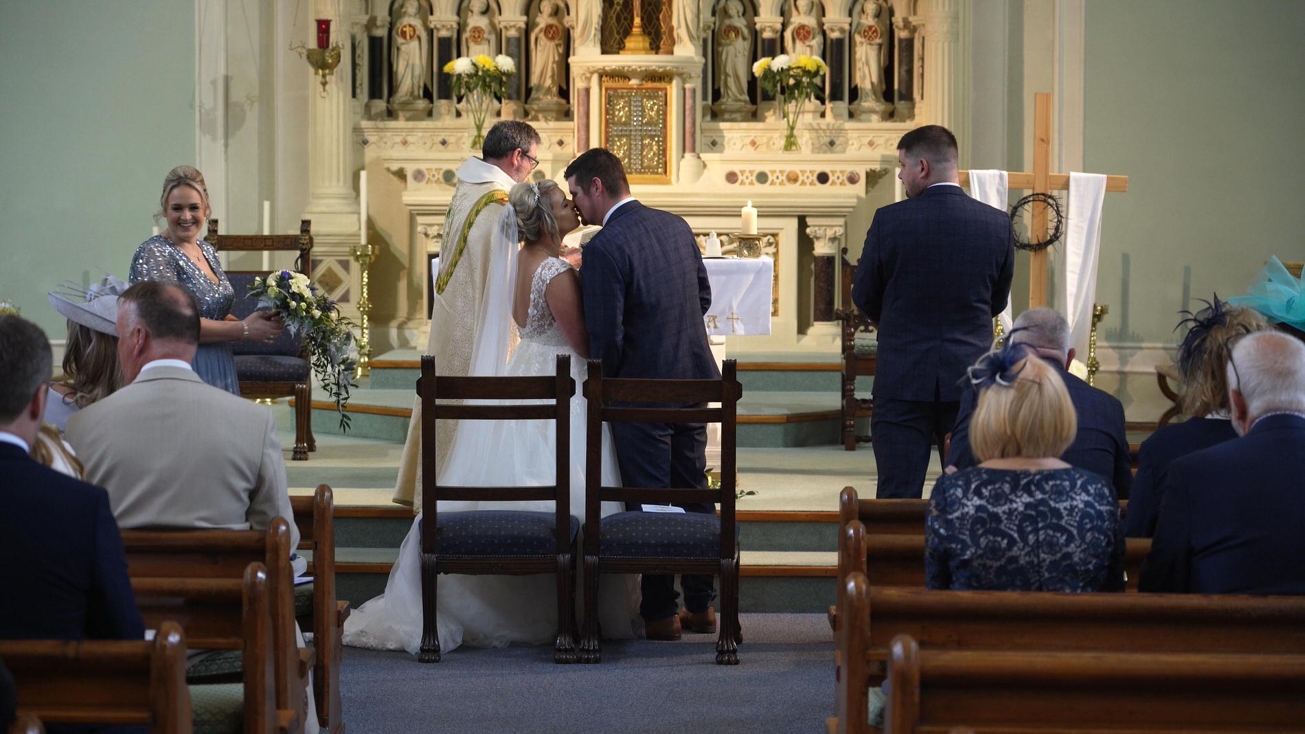 the bride and groom kiss during the ceremony at St gregory's church