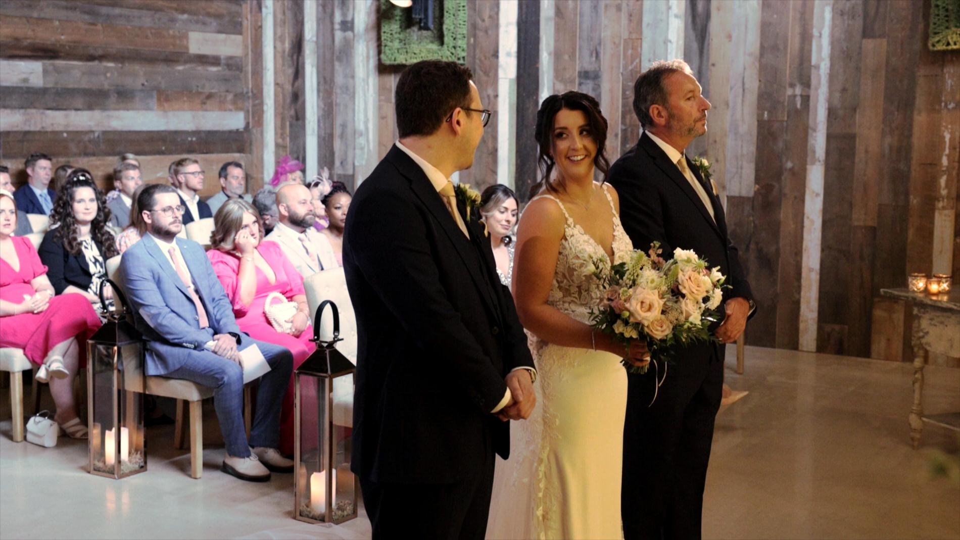bride smiles at her groom during wedding ceremony