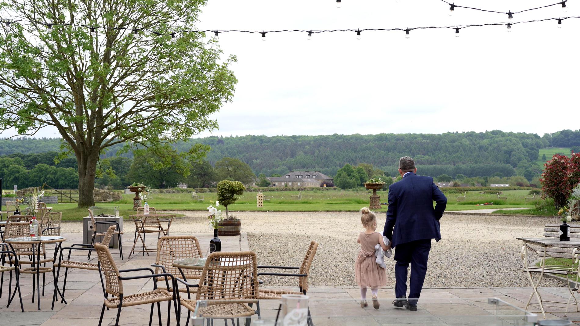 a grandad walks with a child at wedding