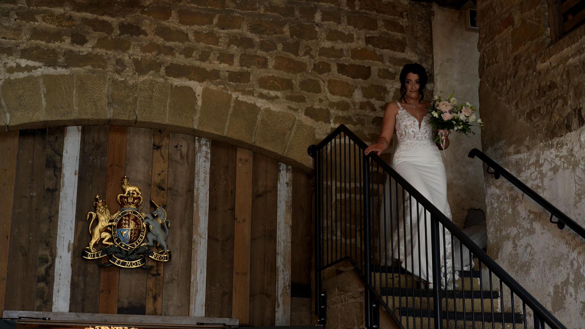 a bride walks down the stone barn steps at Wharfdale Grange