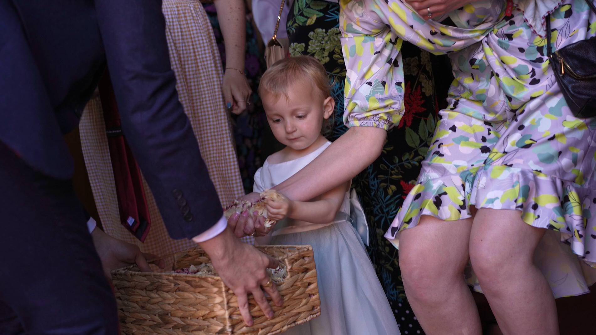 flower girl grabs a handful of confetti