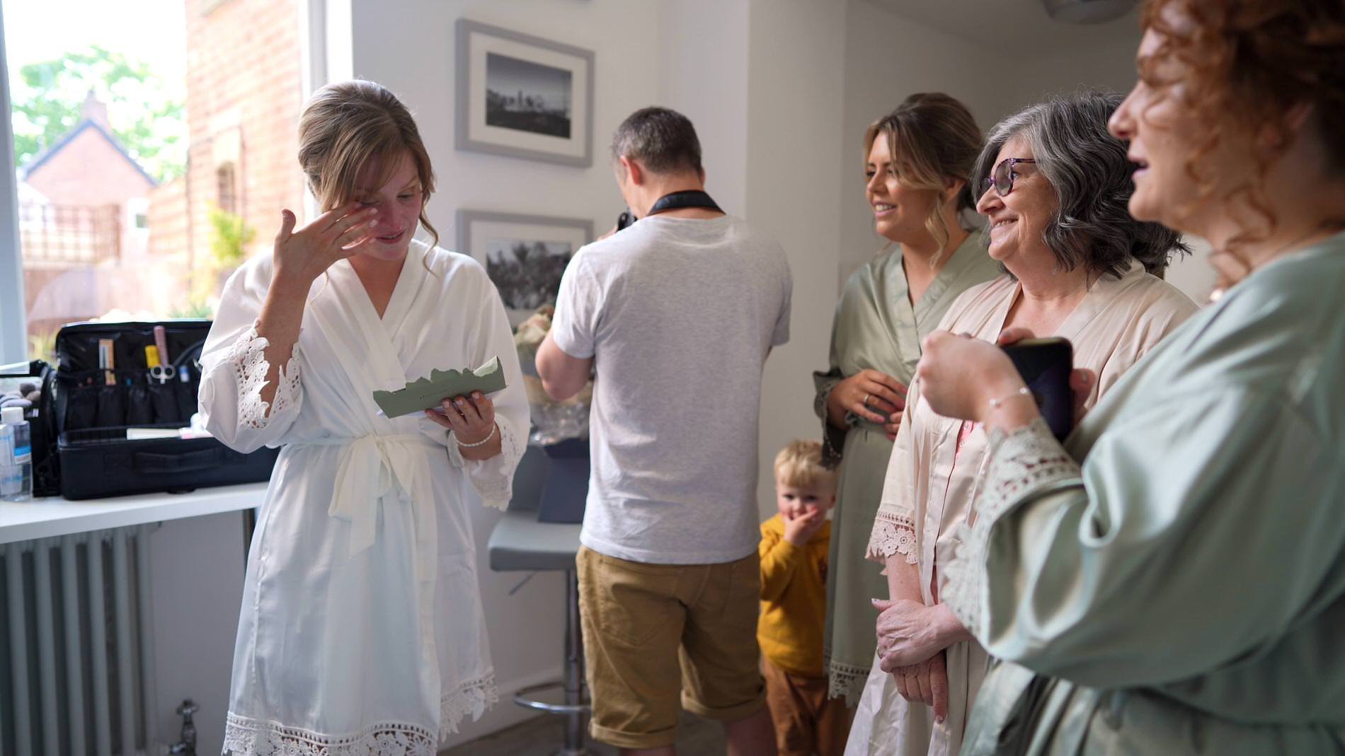 bride wipes a tear away reading her husband to bes card