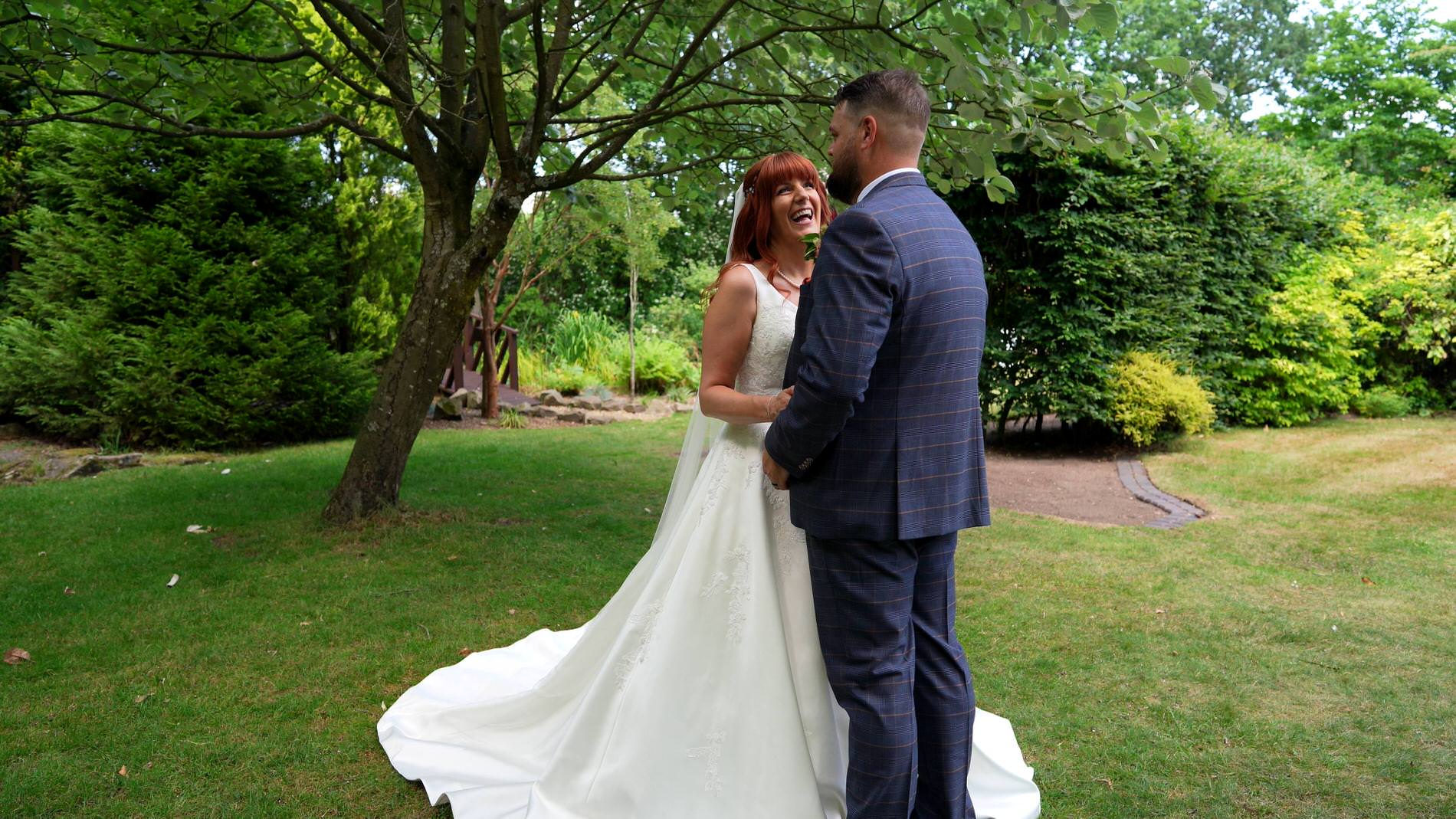 the couple laugh for the videographer at Nunsmere hall