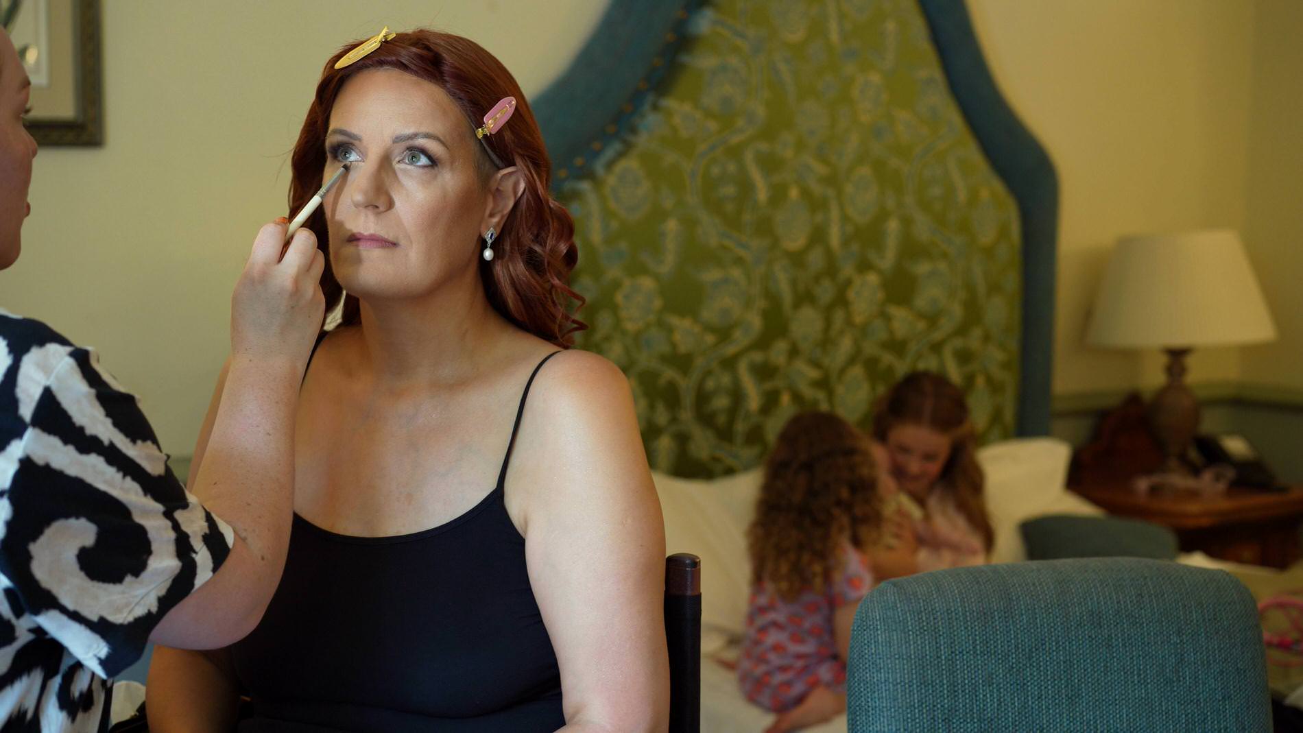 bride has makeup applied in bridal suite