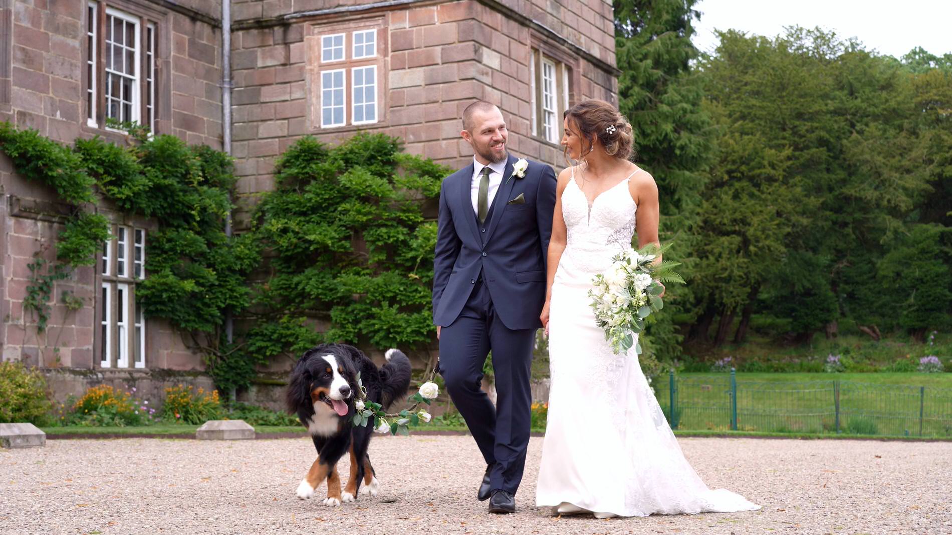 a happy couple walk with the dog outside Browsholme Hall with videographer