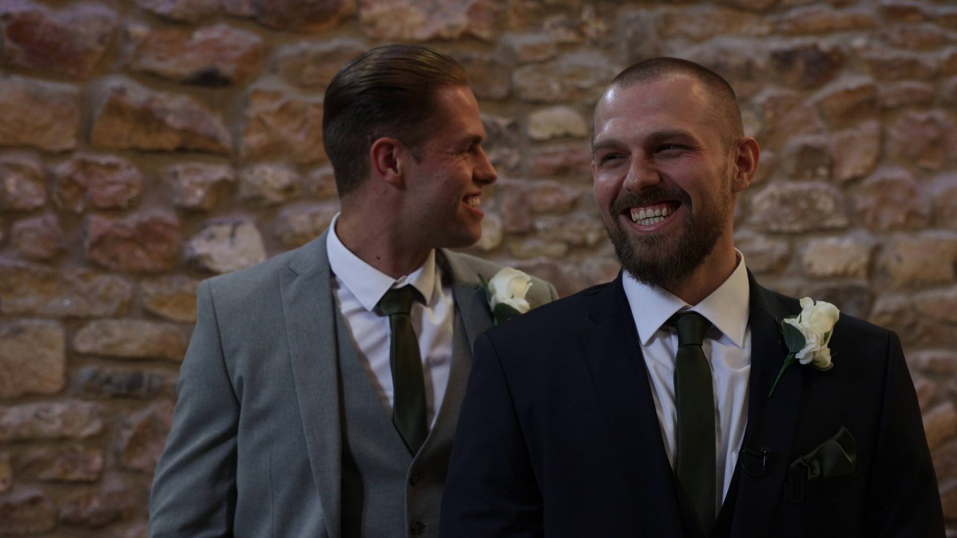 the groom laughs whilst waiting for the bride