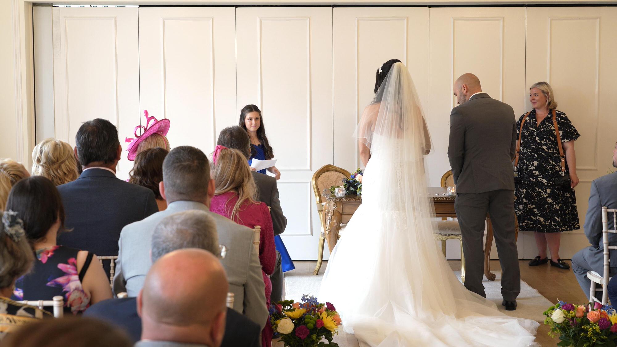 the couples daughter stands to do a wedding reading