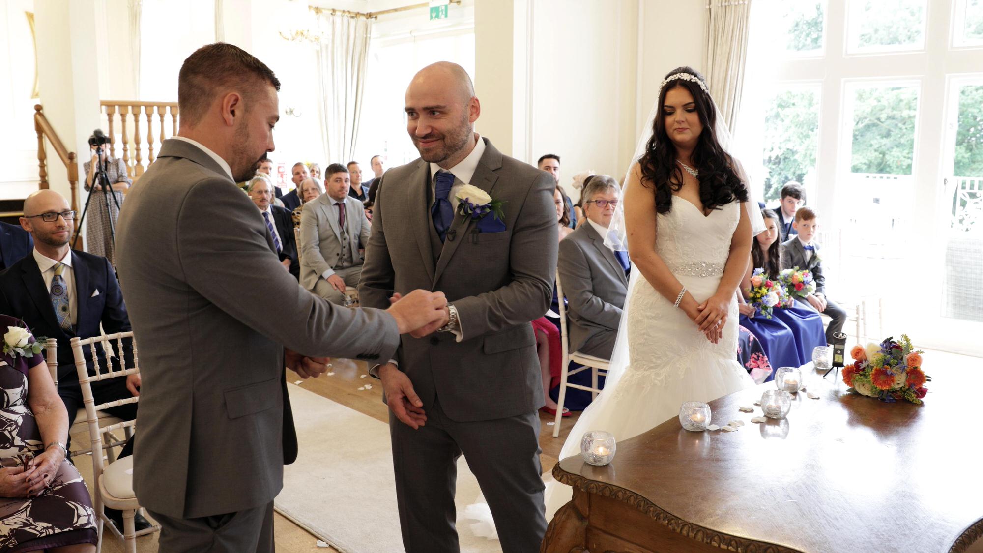 the best man passes on the wedding rings during the West Tower ceremony