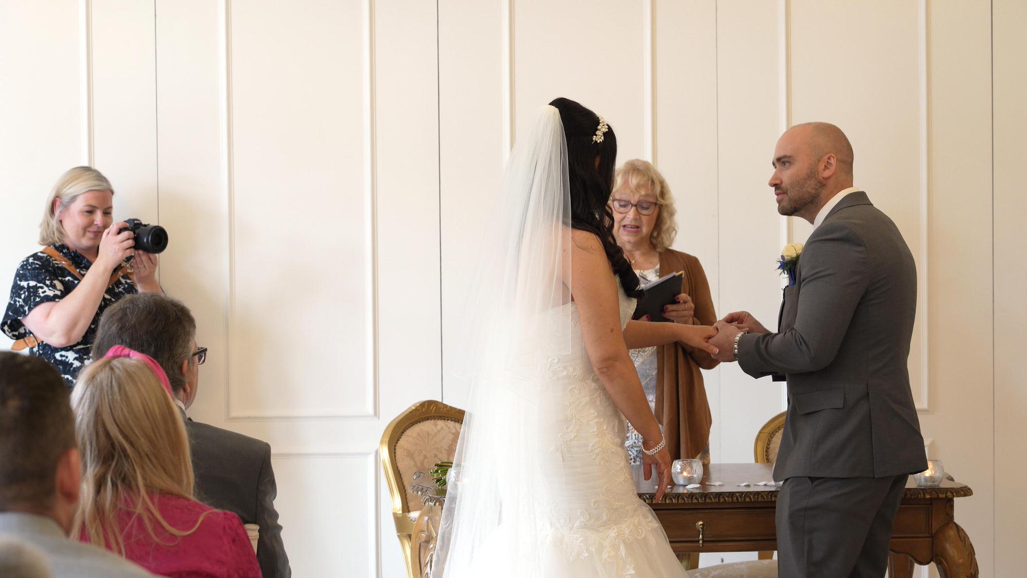 the groom slides on the brides wedding ring