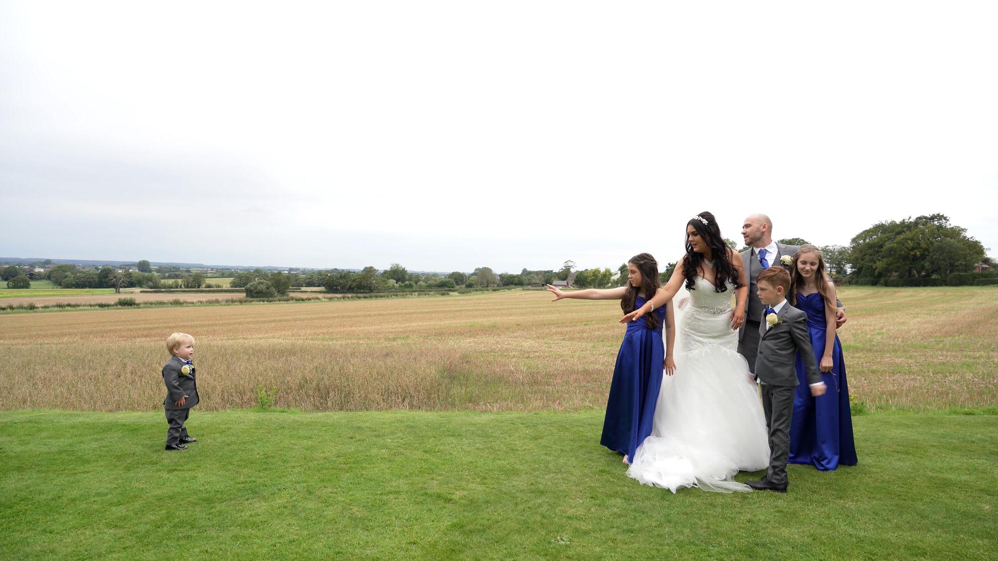 the family reach out to tempt the baby in to a group photo at West Tower