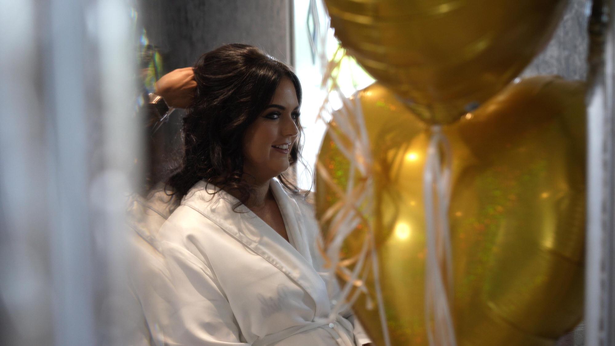 a bride smiles in the mirror in the Crystal suite at West Tower
