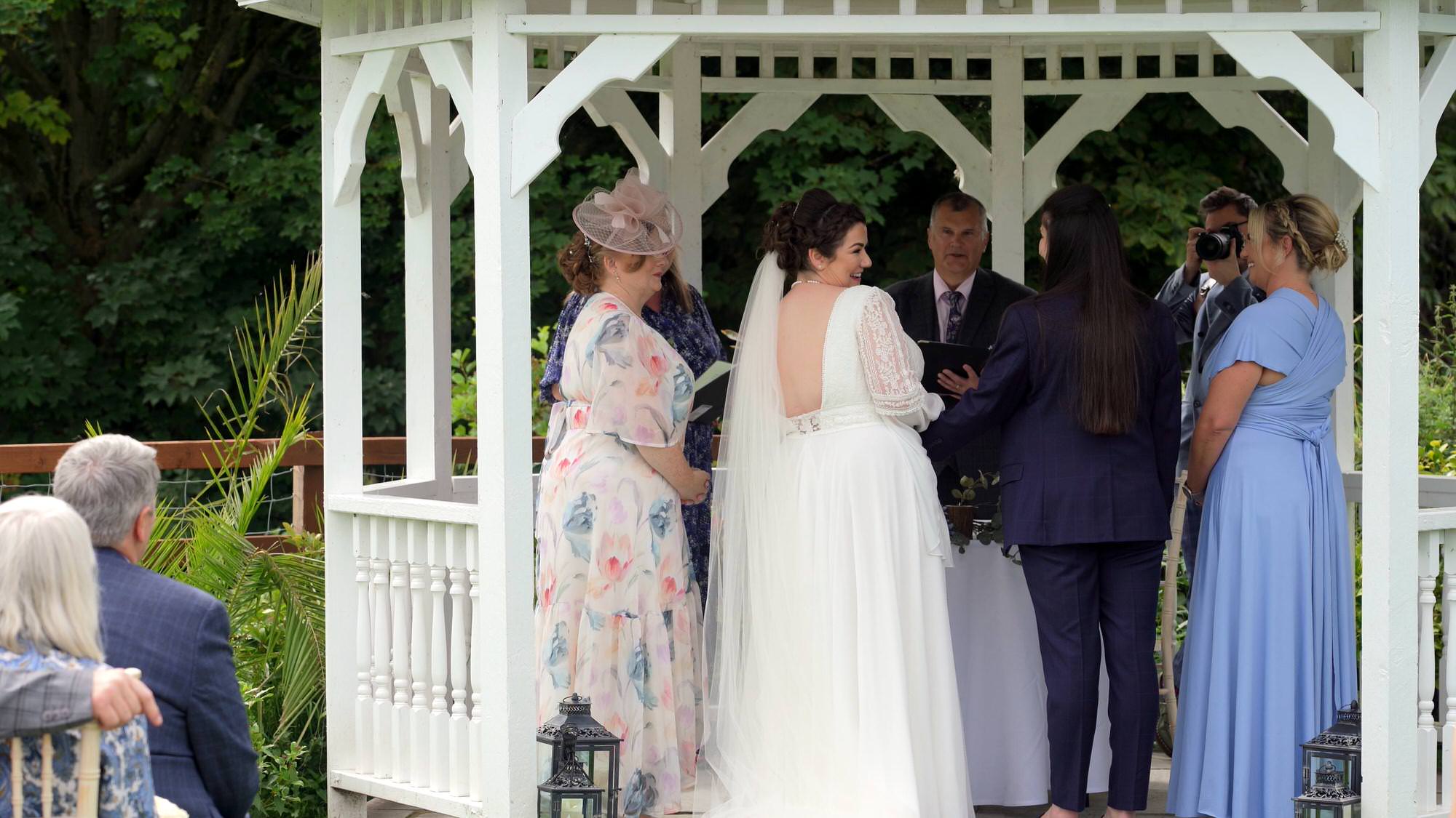 the couple laugh during an outdoor ceremony at The Aviary in Ormskirk