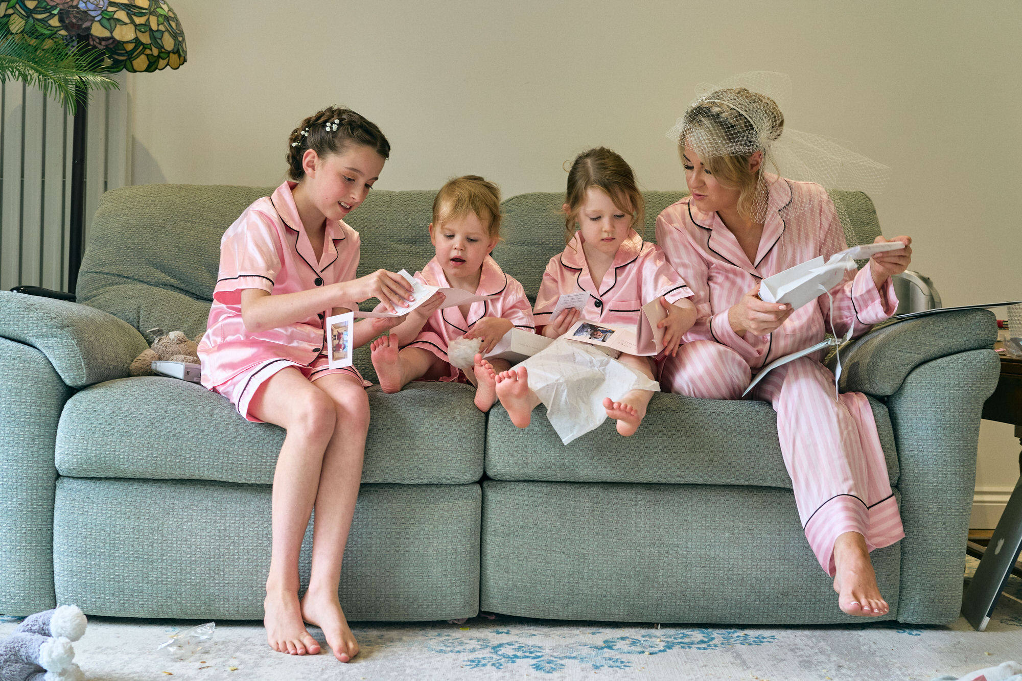 a video still of a bride sitting with flower girls reading wedding cards