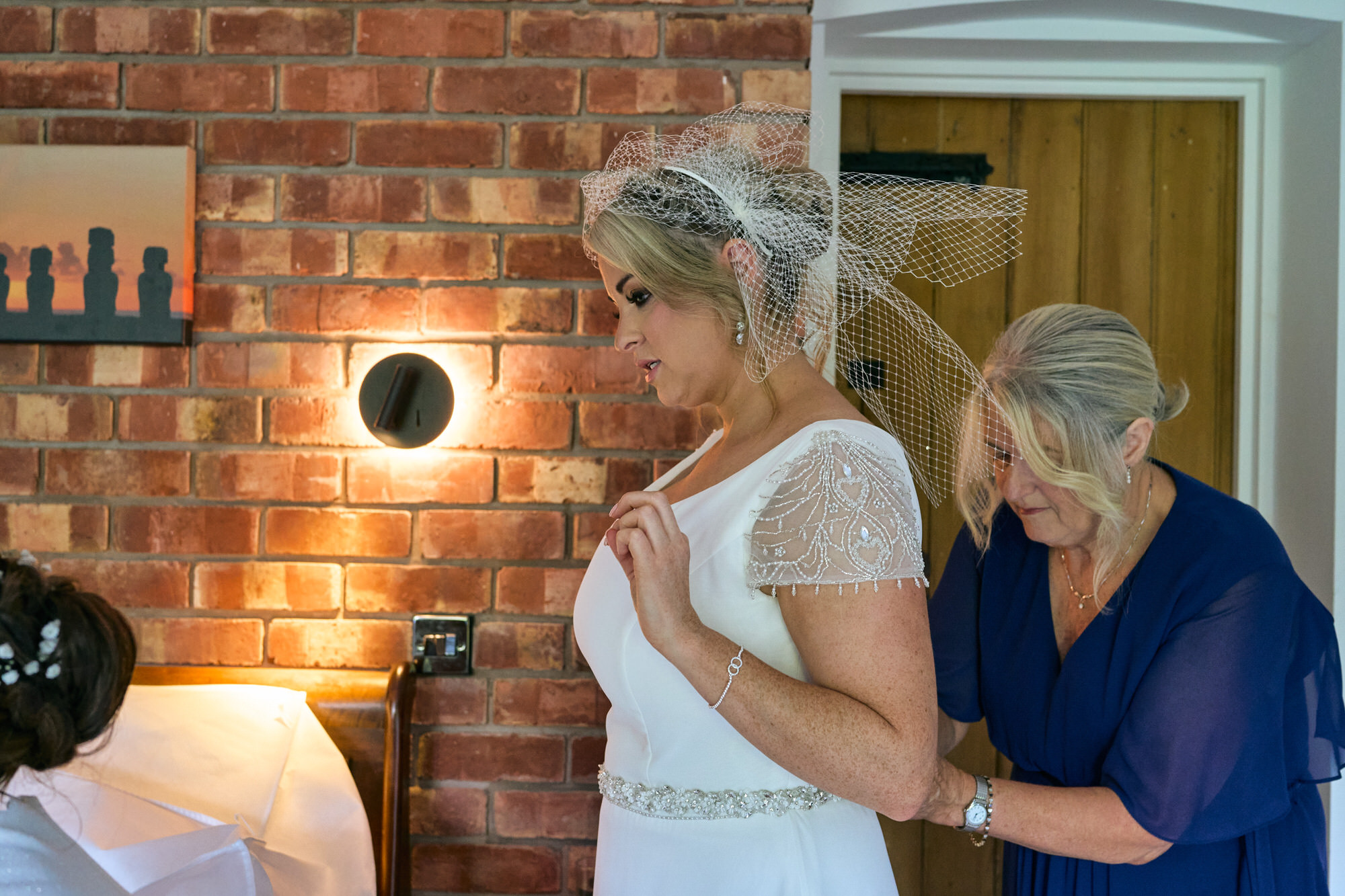 Mum helps her daughter get in to her wedding dress