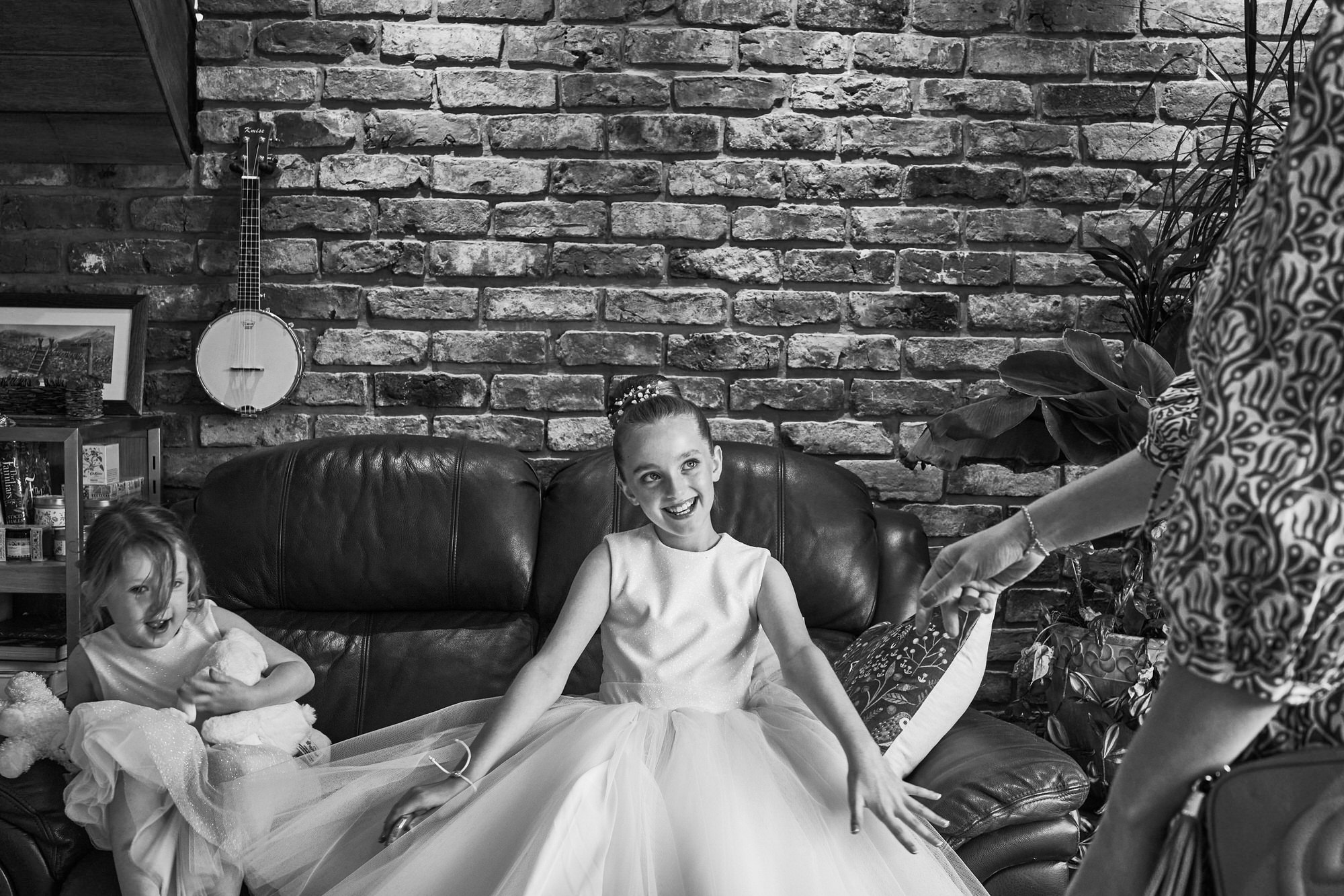 a flower girl grins as she's complimented about her dress