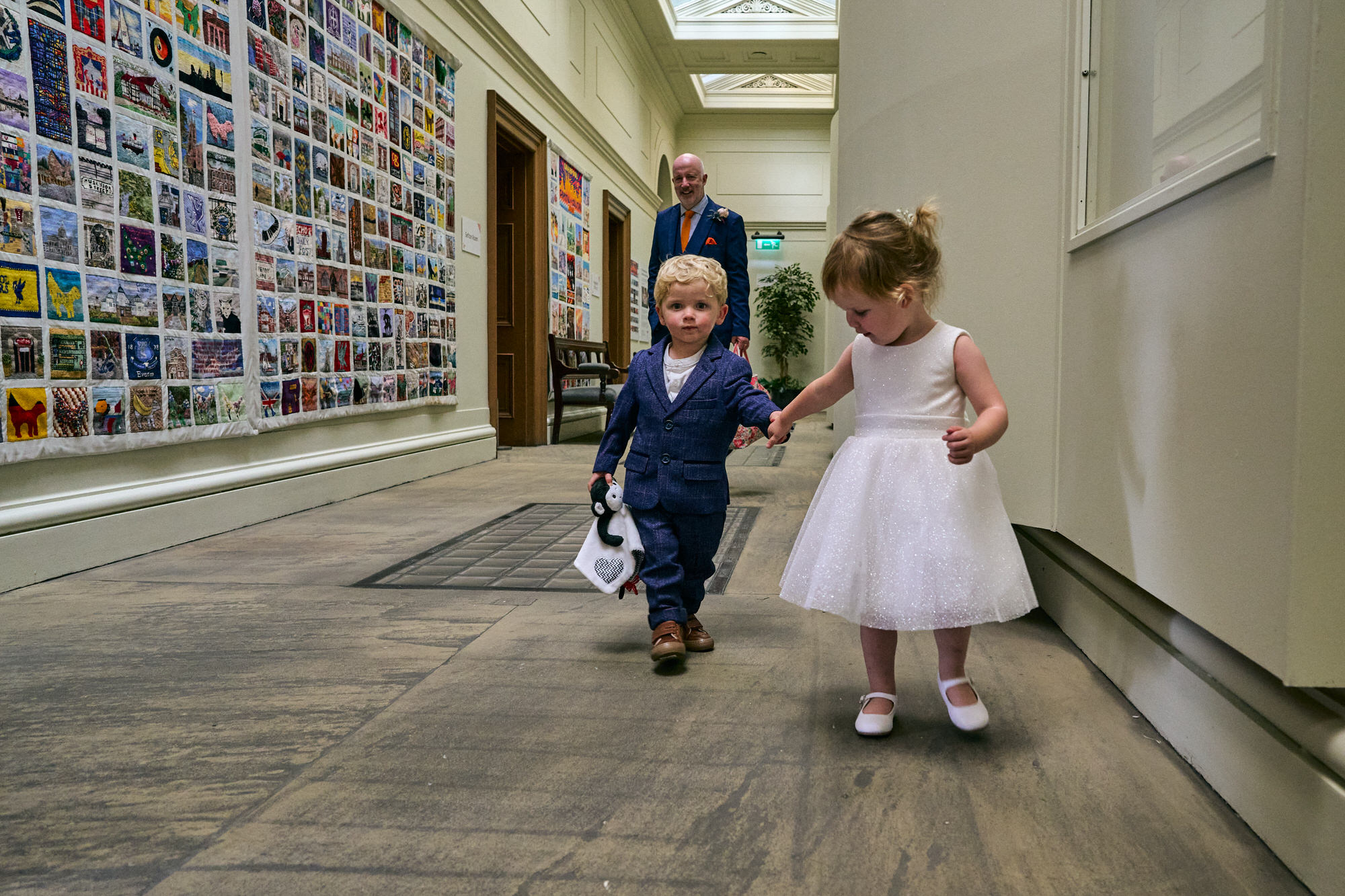 a little flowergirl leads a page boy to the Jury room at St Georges Hall in Liverpool