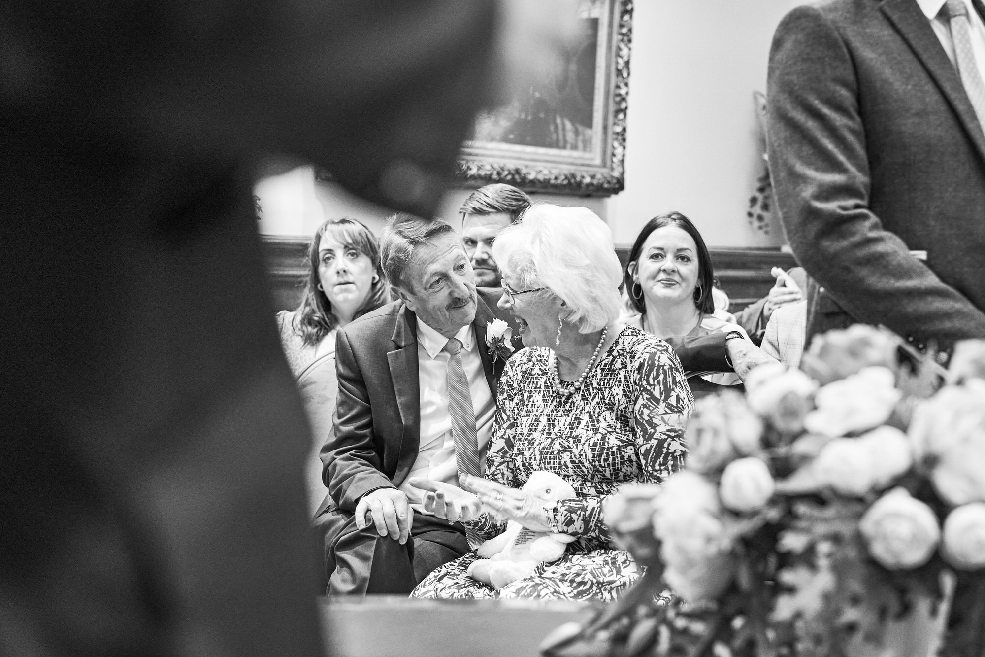 a candid photo of the grooms parents getting emotional during the ceremony