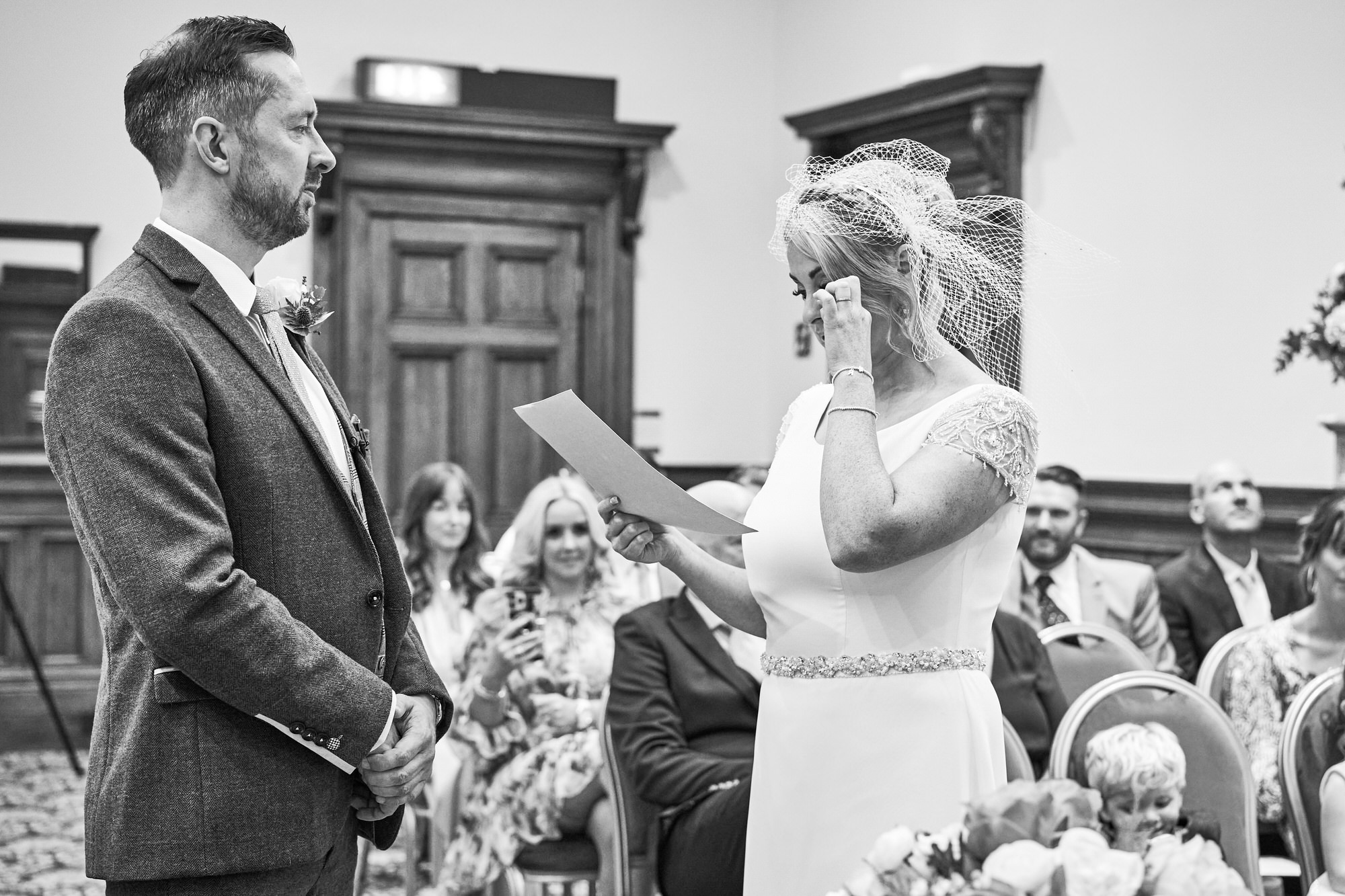 the bride wipes a tear away during ceremony at St Georges Hall