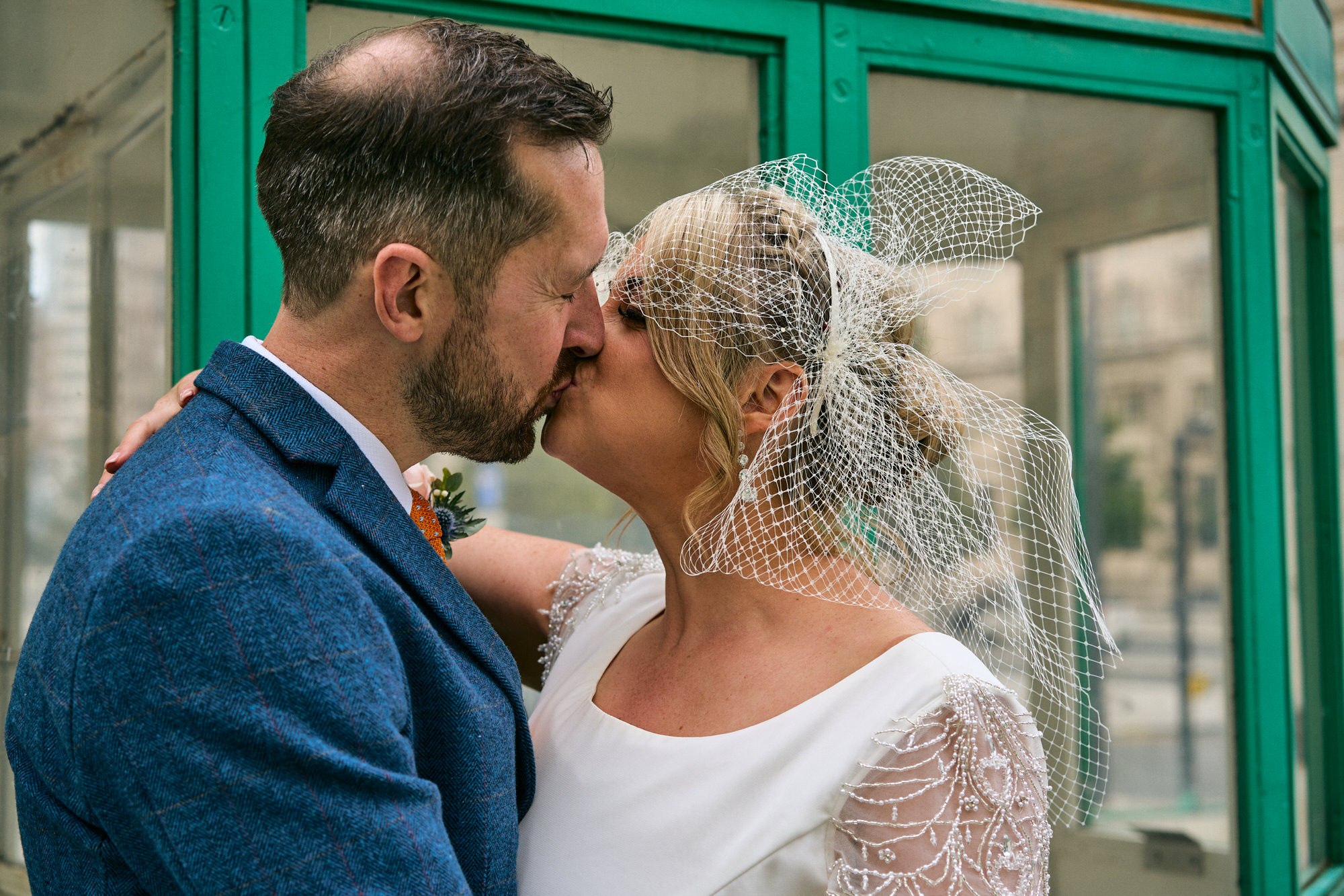 bride and groom kiss beside the old mersey toll booth on the waterfront