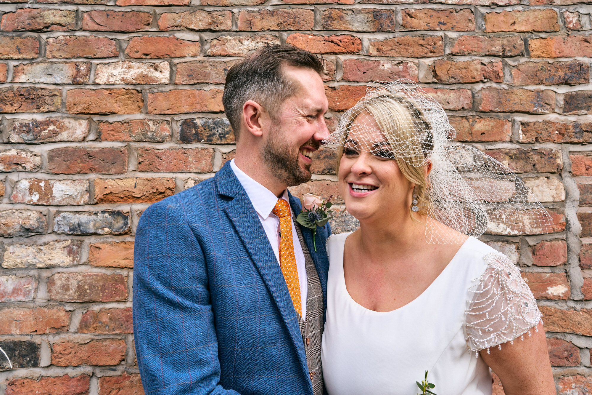 the couple laugh with the photographer walking around the Georgian quarter Liverpool
