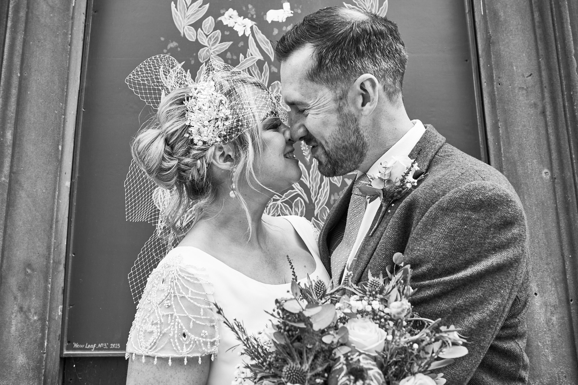 a bride and groom smile at each other for photos around Liverpool
