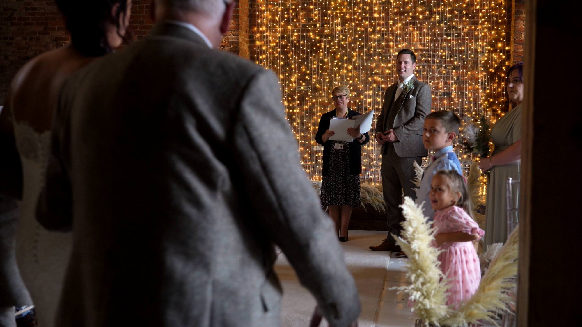 a videographer films the groom seeing his bride for the first time