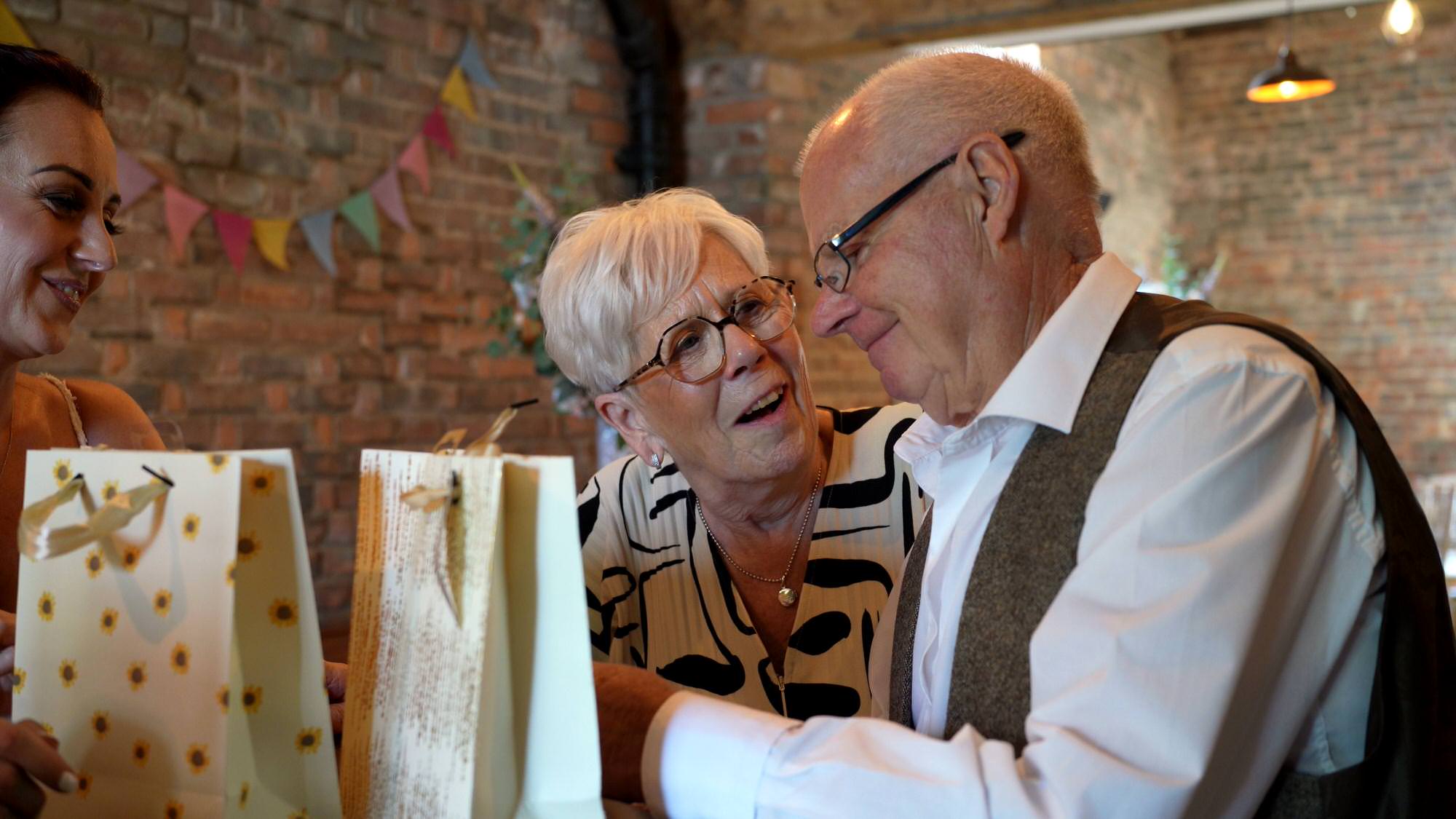 video still of grandparents getting emotional opening gifts