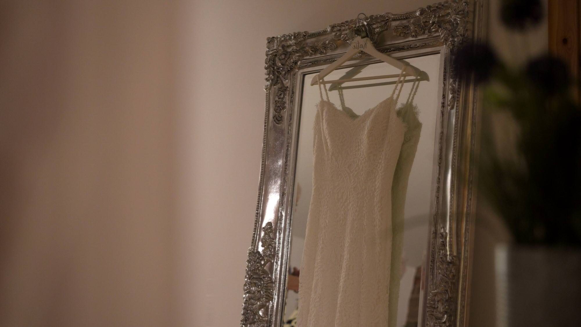 a lace wedding dress hangs at the barn at morleys hall