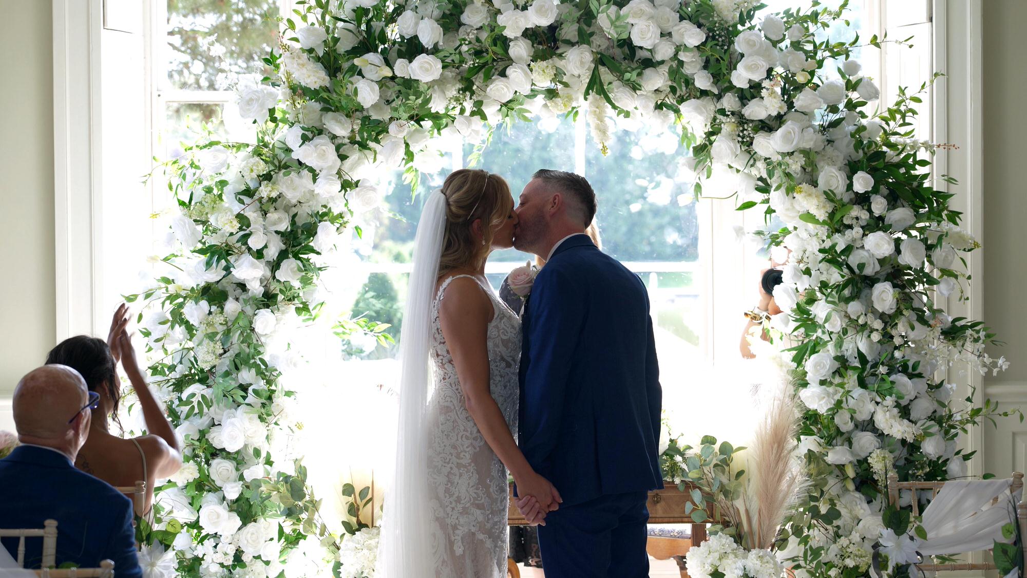 a couple kiss in front of a floral moon ate at Stubton Hall Newark