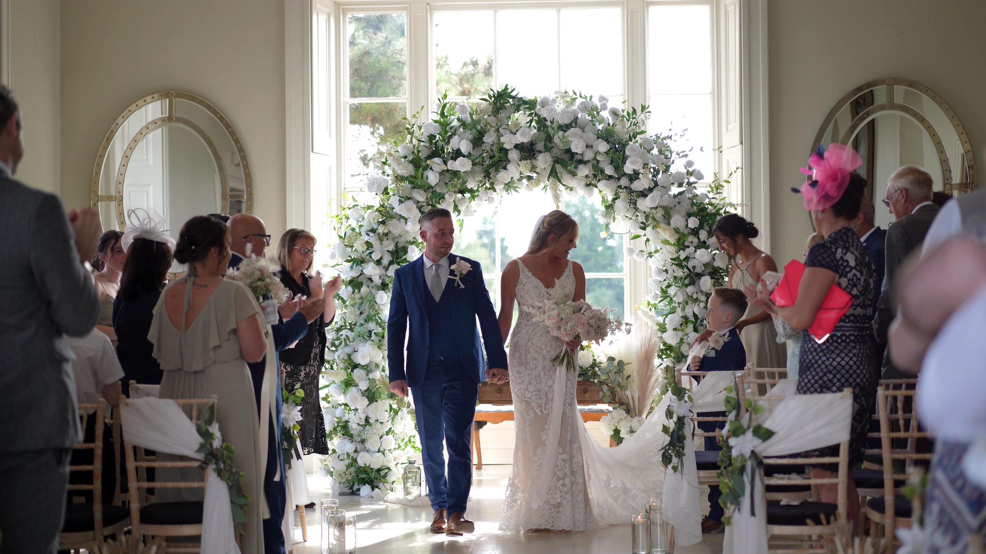 a couple walk back down the aisle to the videographer filming at Stubton Hall Newark