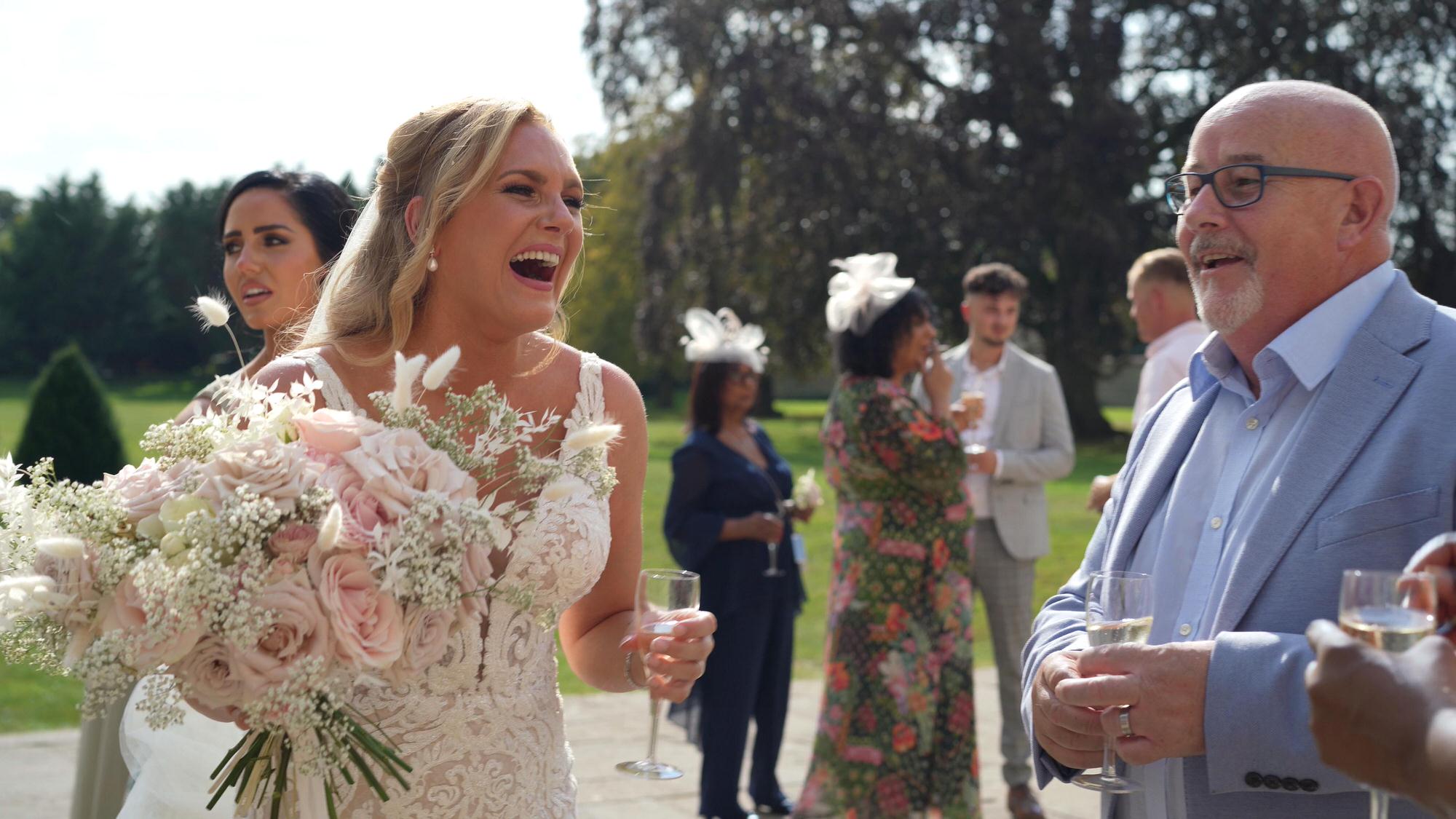 a bride laughs with guests at Stubton Hall Newark