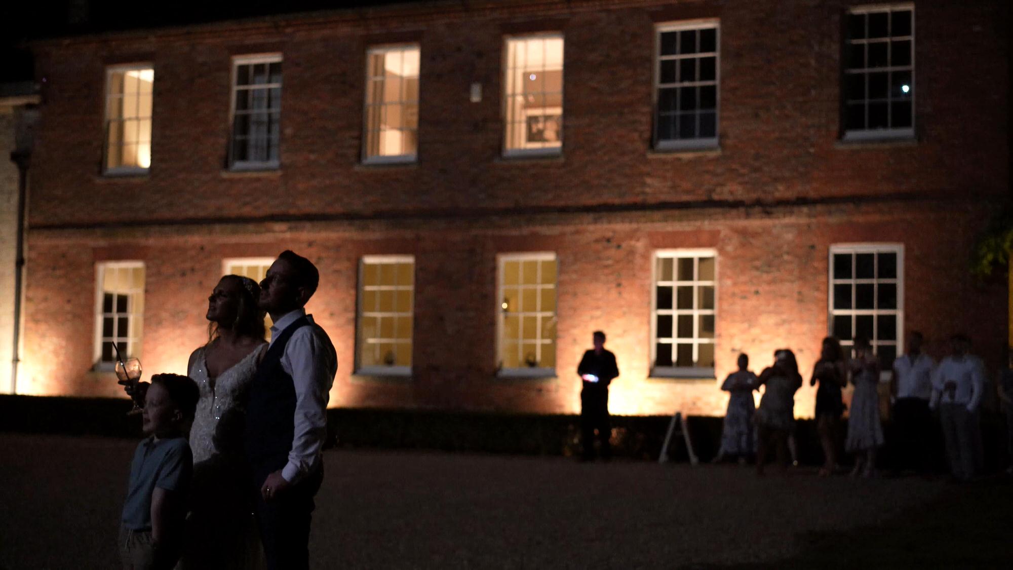 a couple and their son watch fireworks outside Stubton Hall