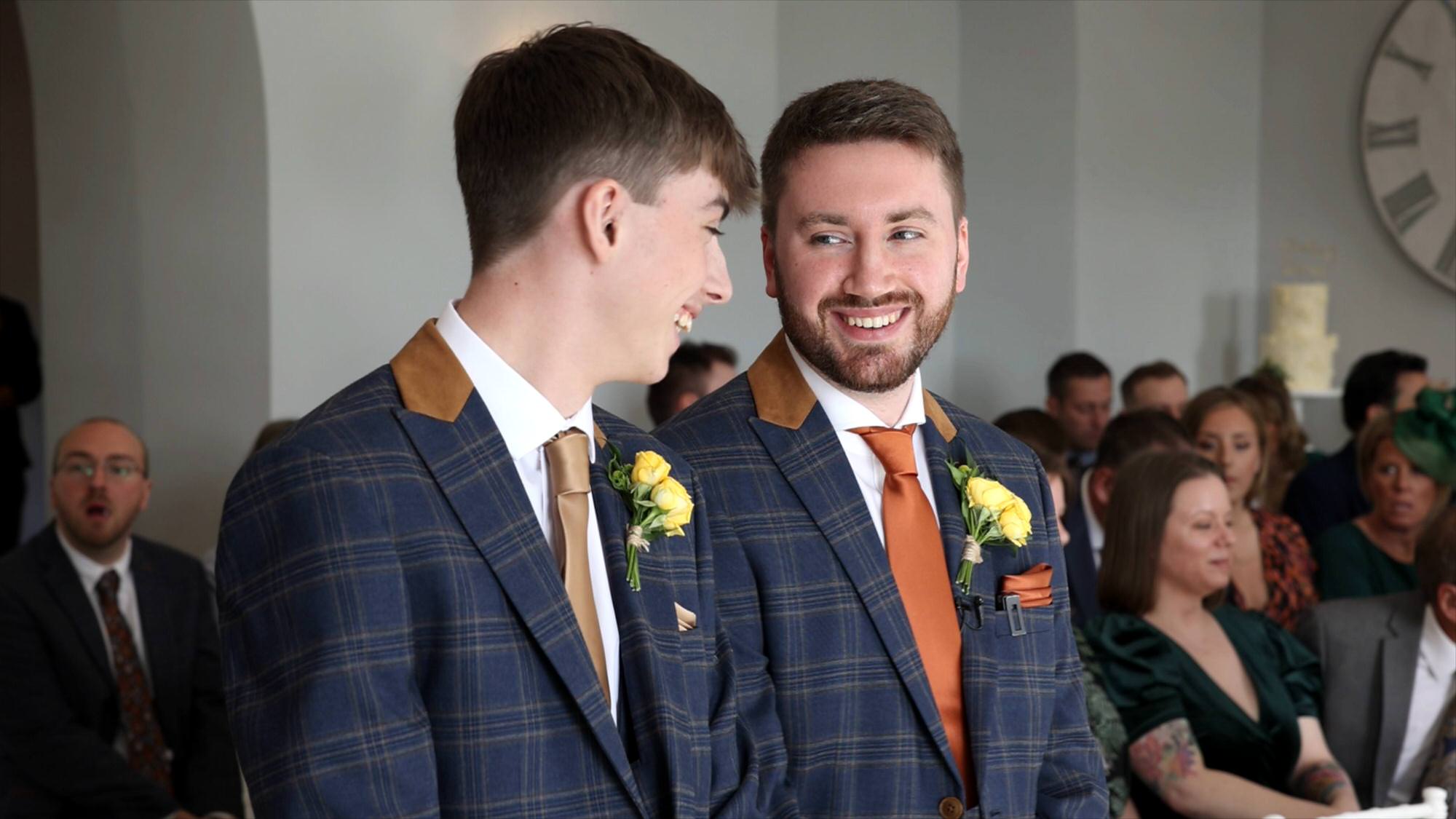 a groom laughs with his best man before the wedding ceremony in Cartmel