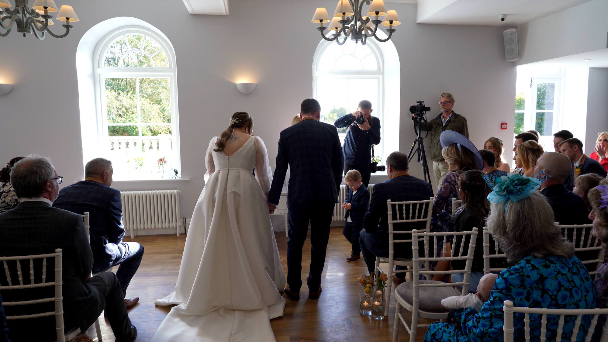 a page boy brings the wedding rings to the front of the lake district wedding ceremony