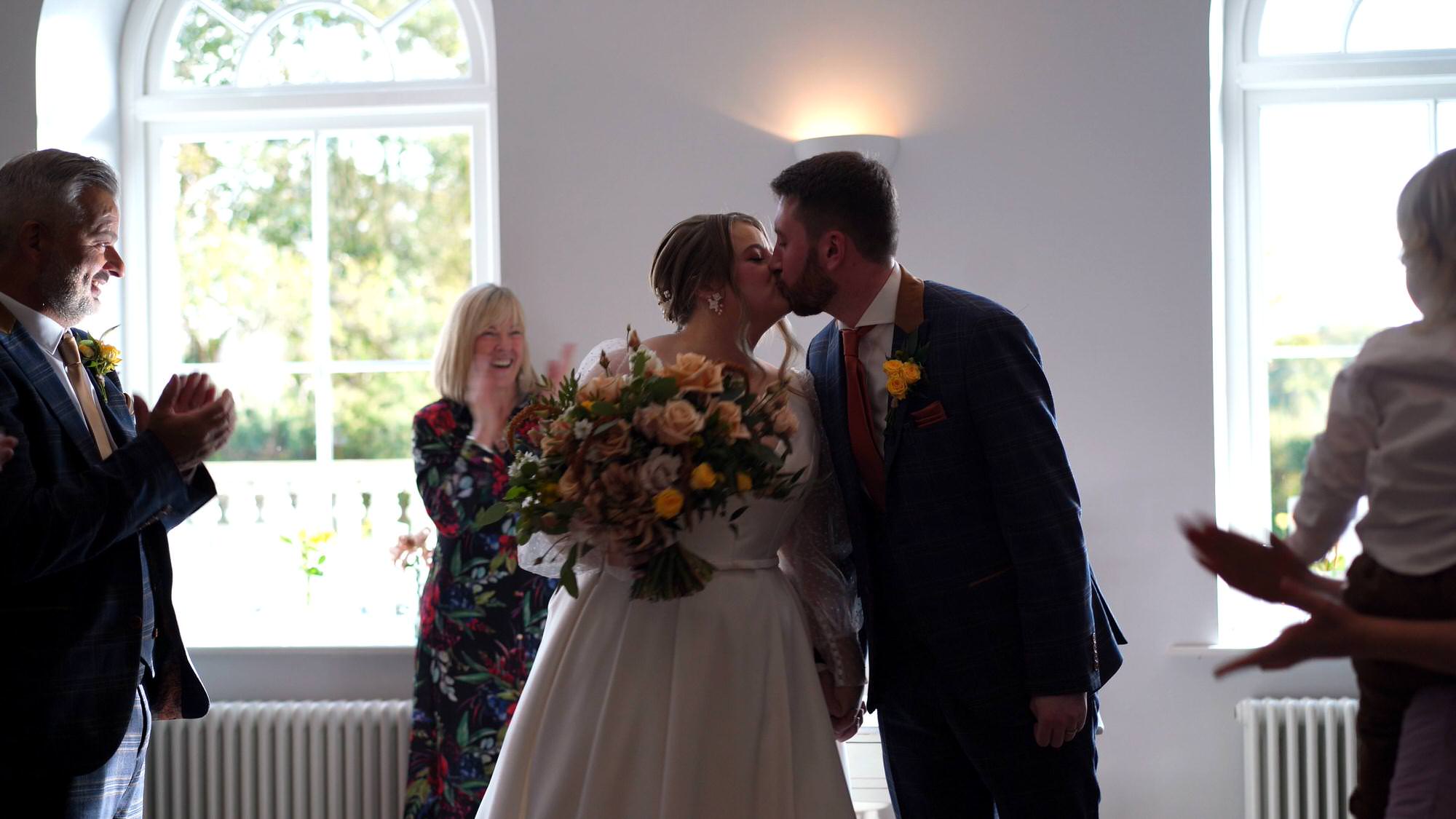 videographer captures a kiss from the couple before they walk down the aisle