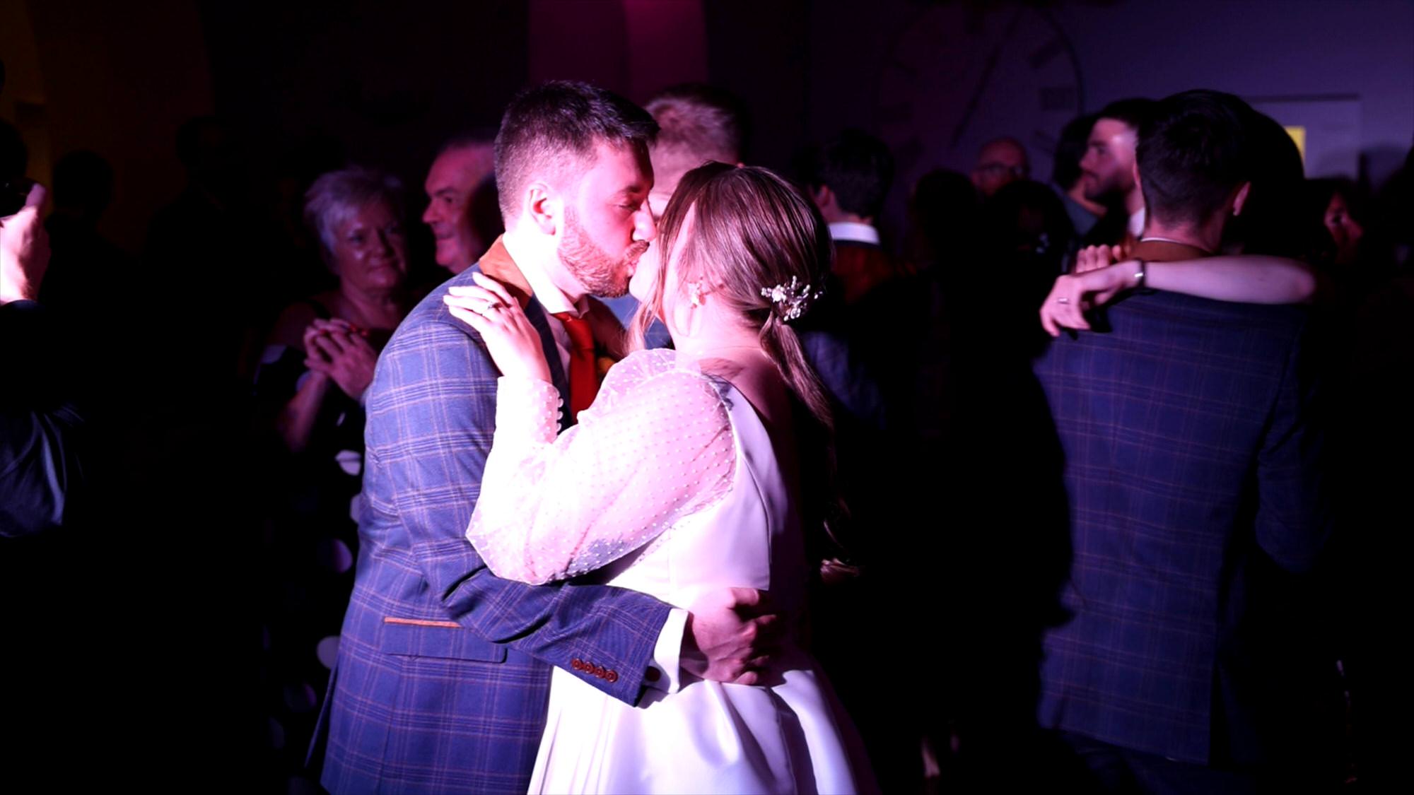 a bride and groom kiss during their first dance