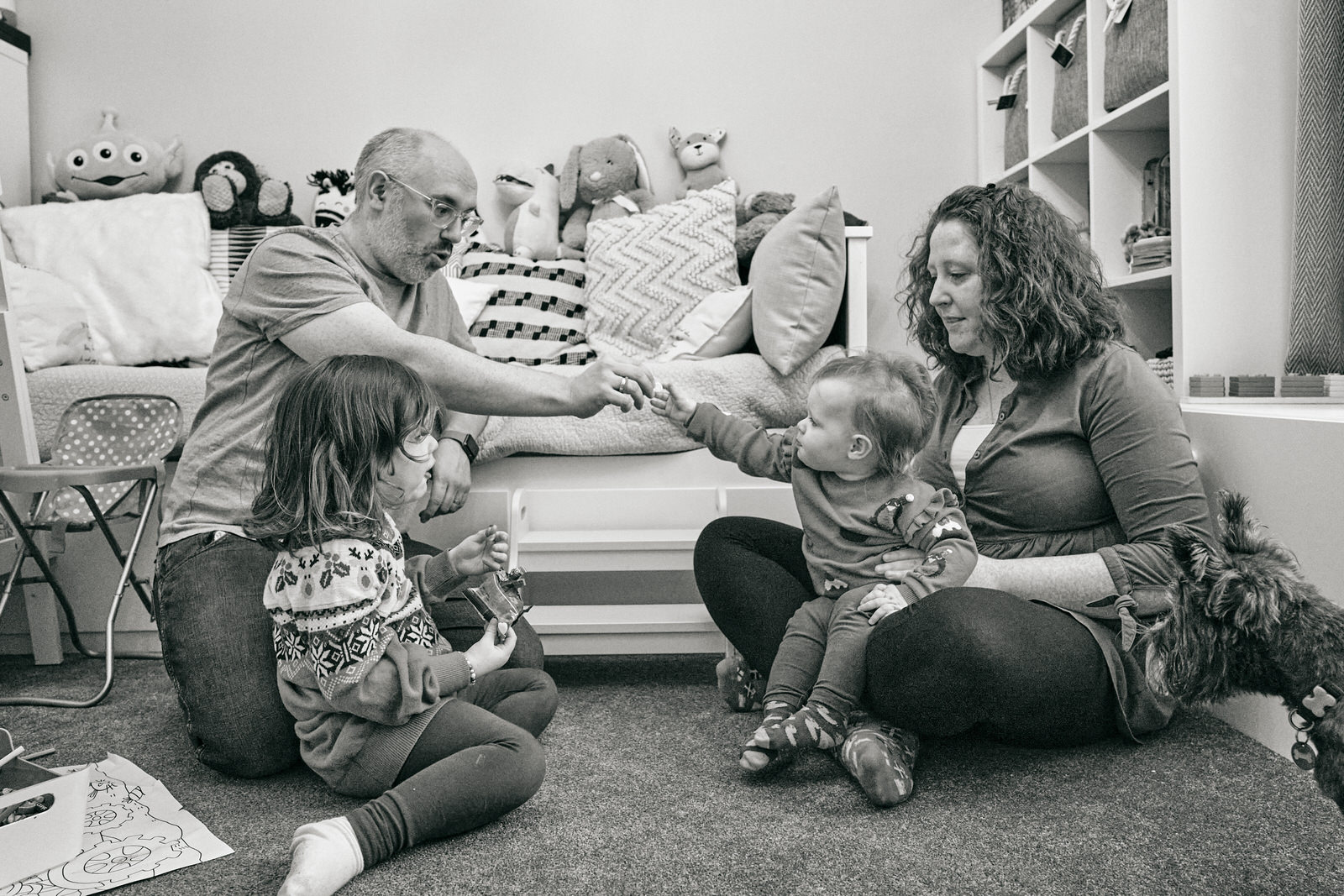 the family sit on the floor and share christmas chocolates