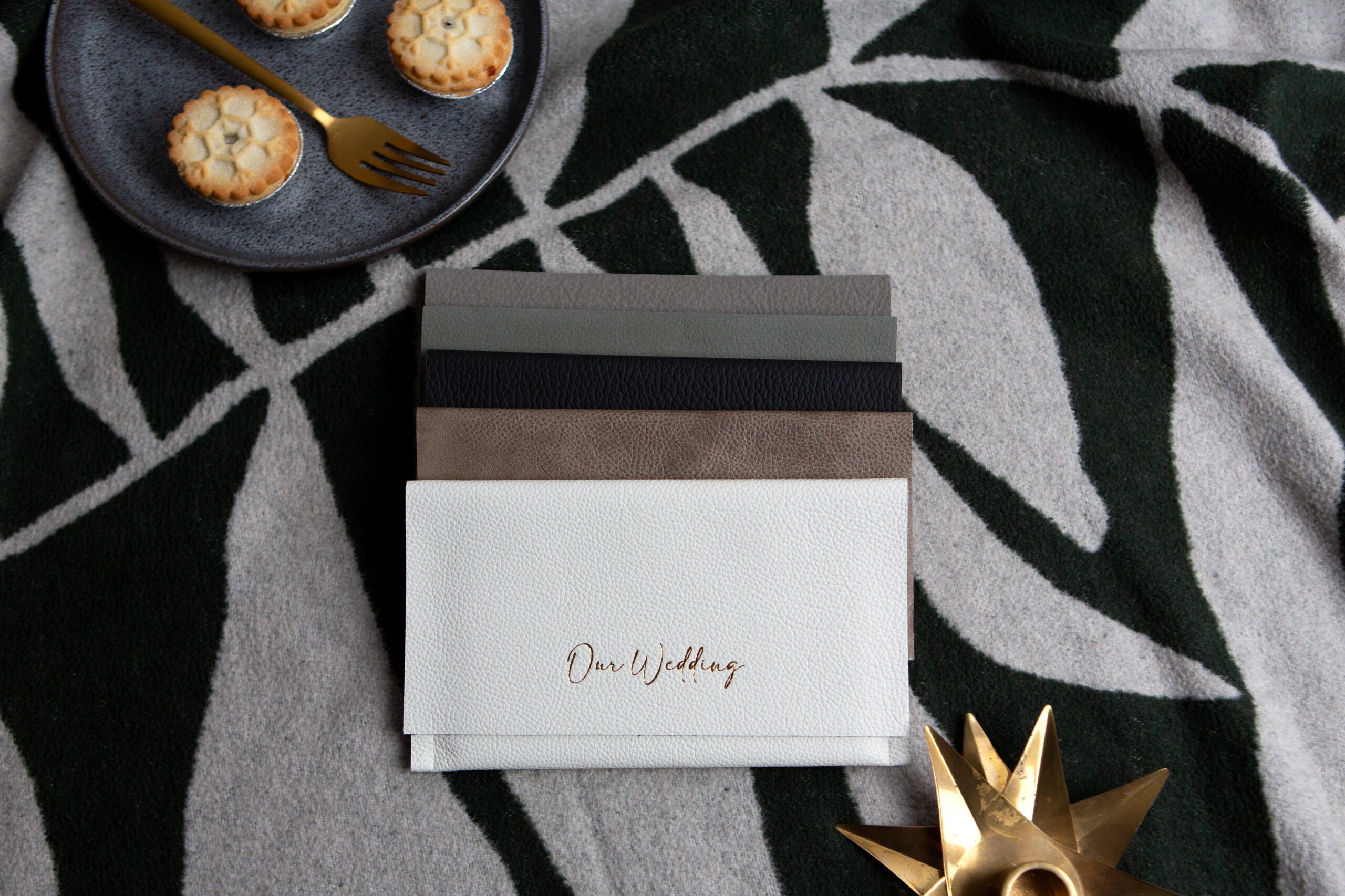 luxury leather wallets on a blanket to showcase a way to organise wedding photos