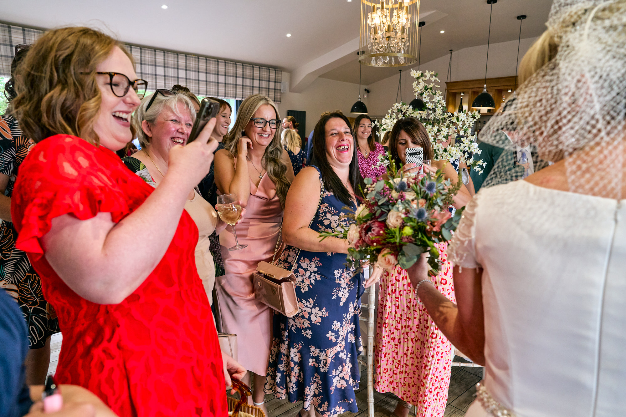 guests stand around to take photos of the newlyweds