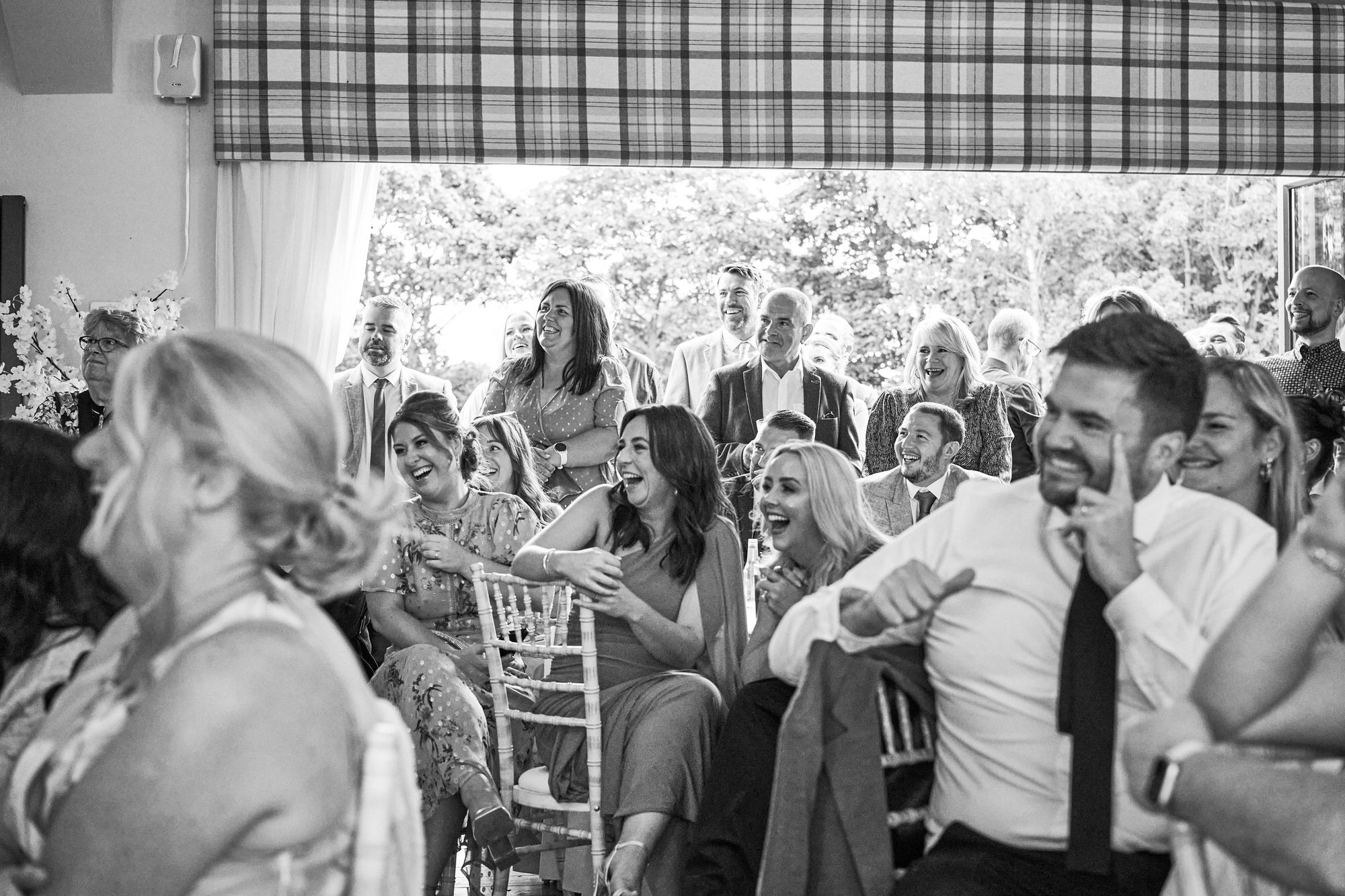 a room of guests laugh during the wedding speeches at The Aviary Ormskirk