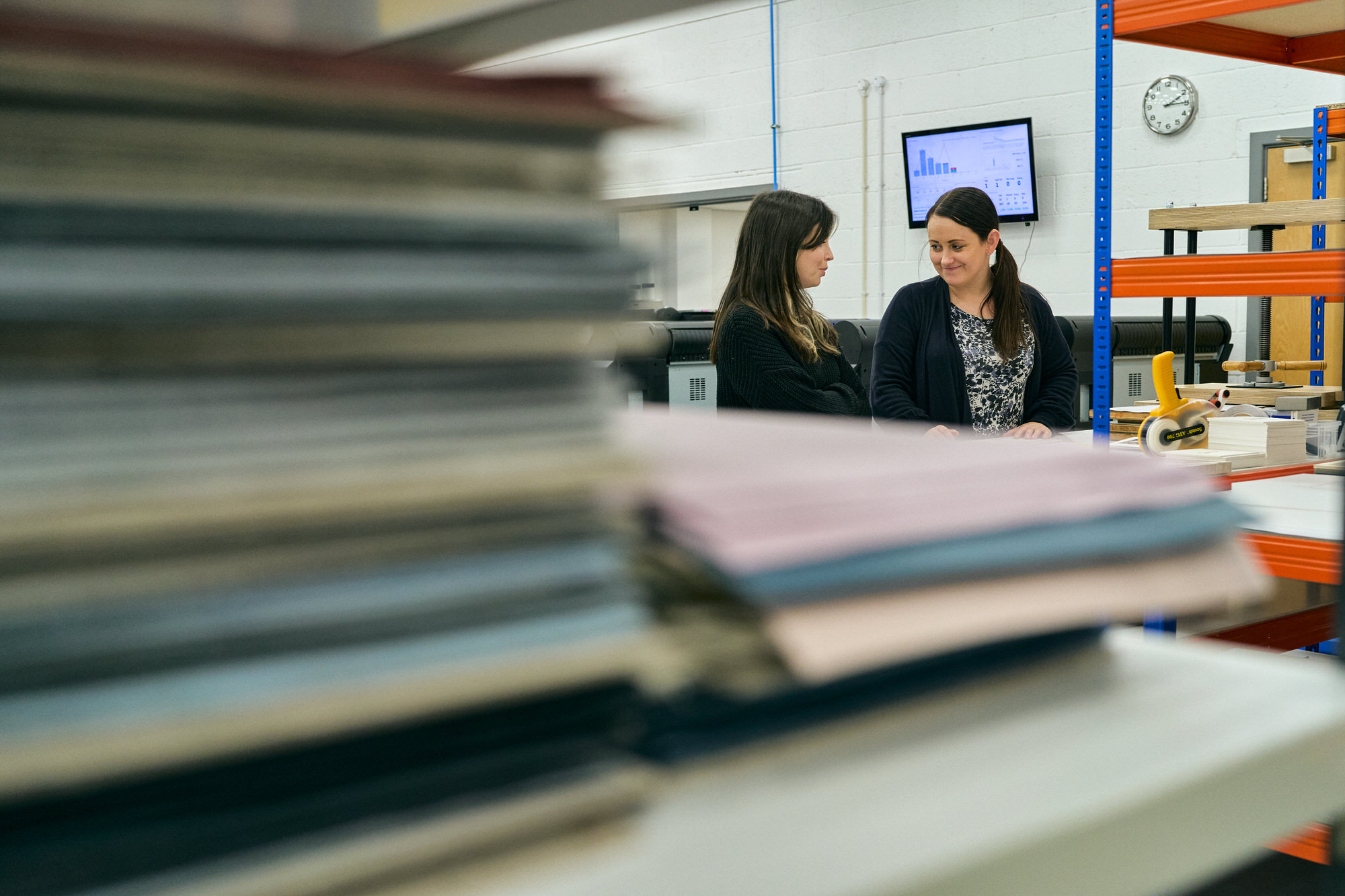 two staff chat in the background of a shot of Folios Workshop