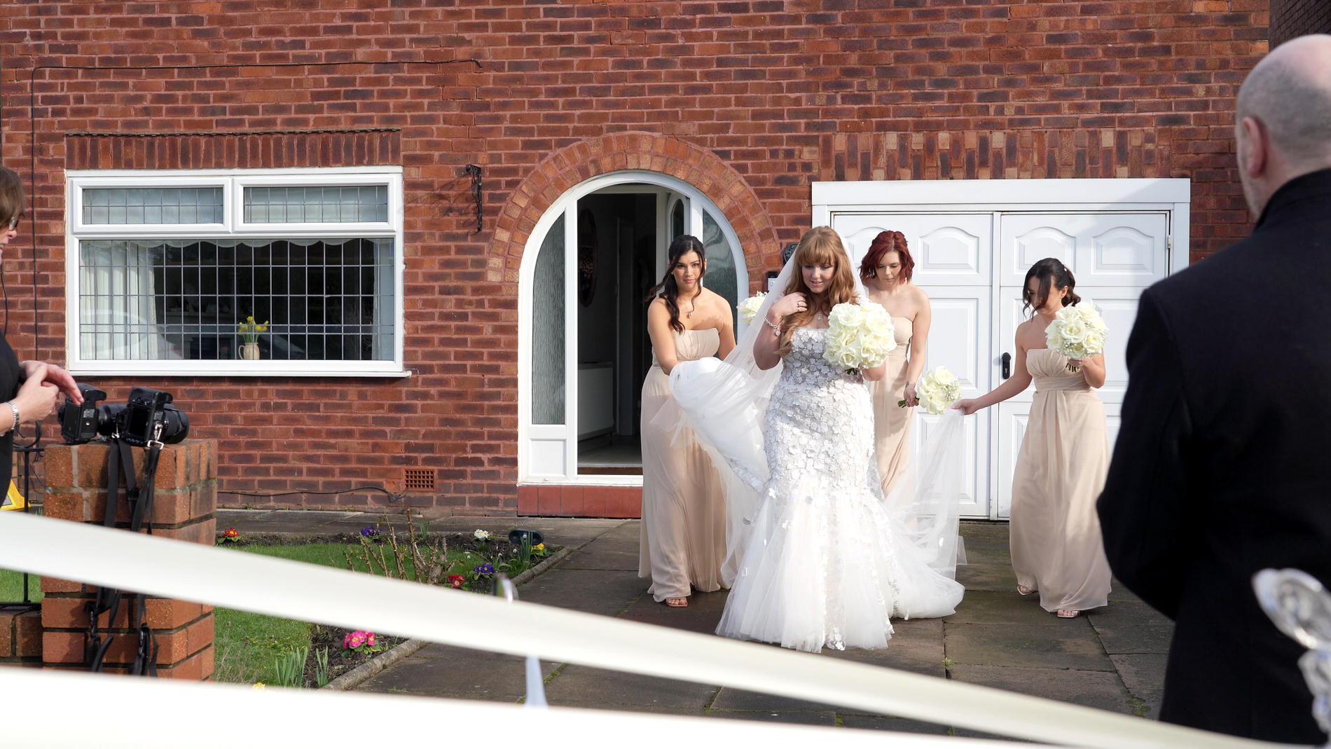 bridesmaids help the bride to her wedding car in Churchtown