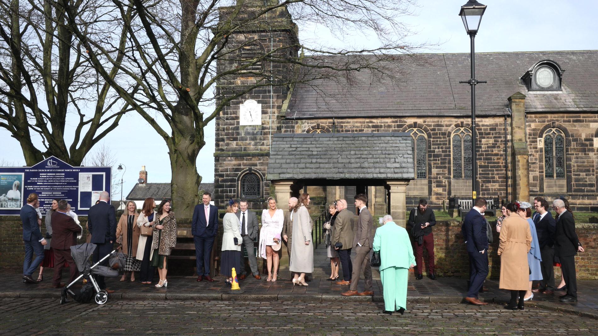 Wedding guests wait outside St Cuthberts in Churchtown
