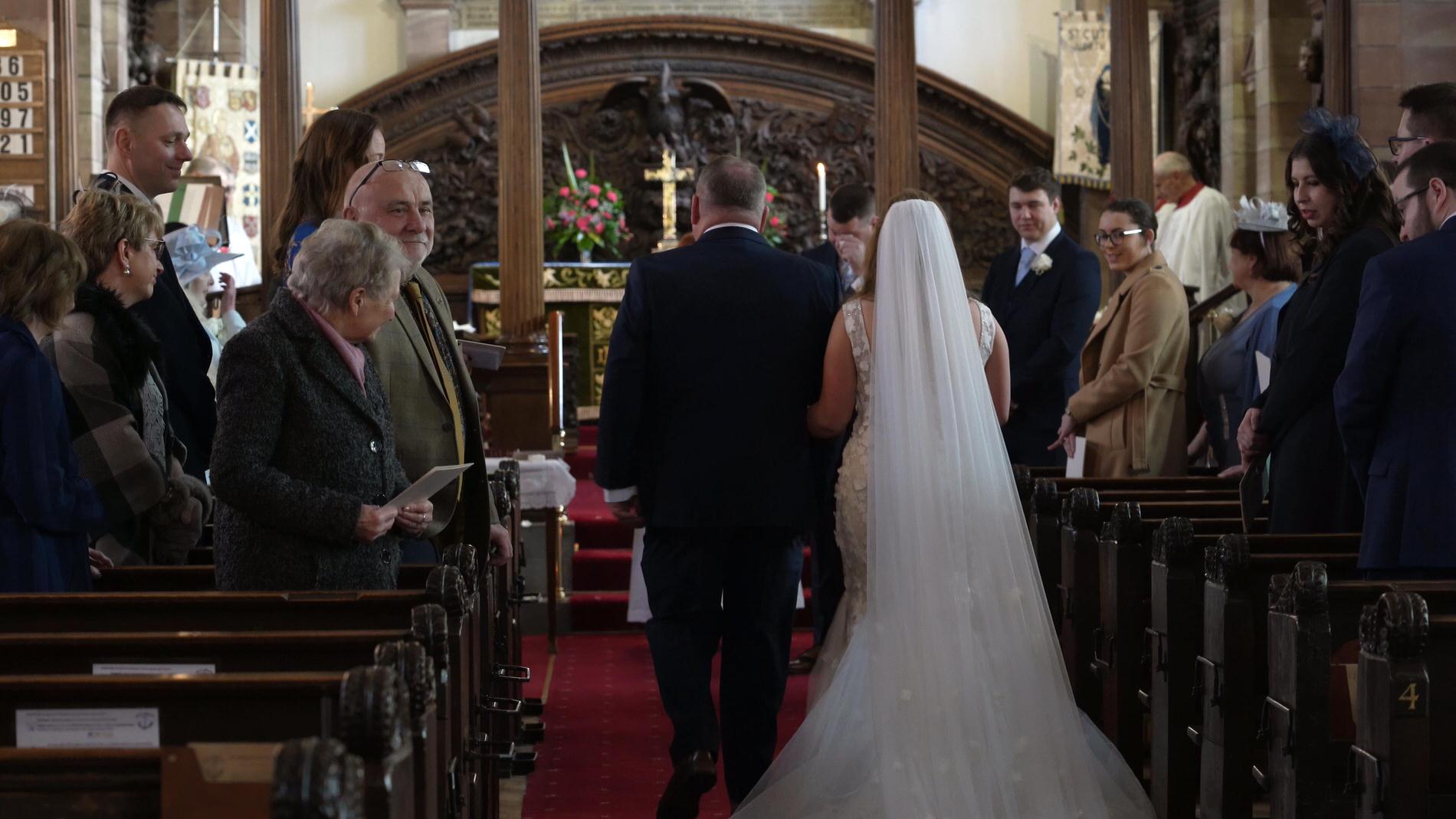 a bride walks down the aisle at St Cuthberts Church in Churchtown