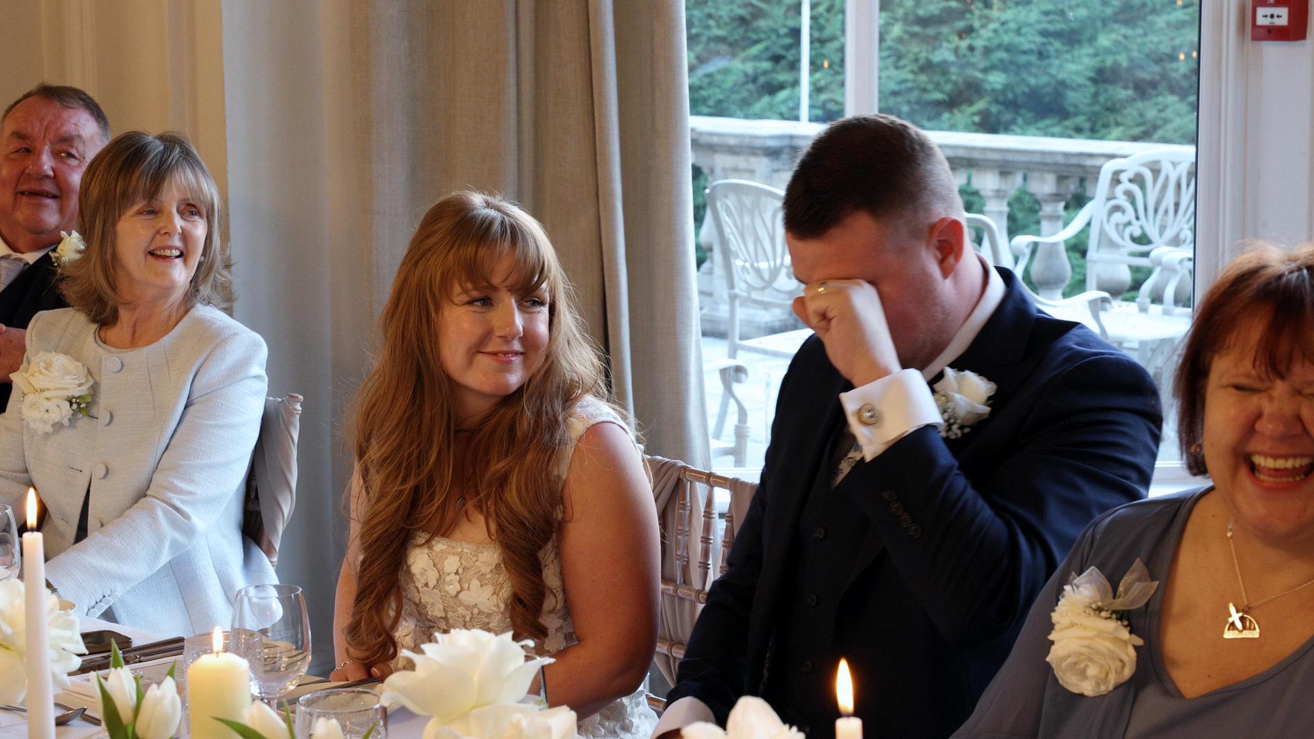the groom wipes away tears during best man speech