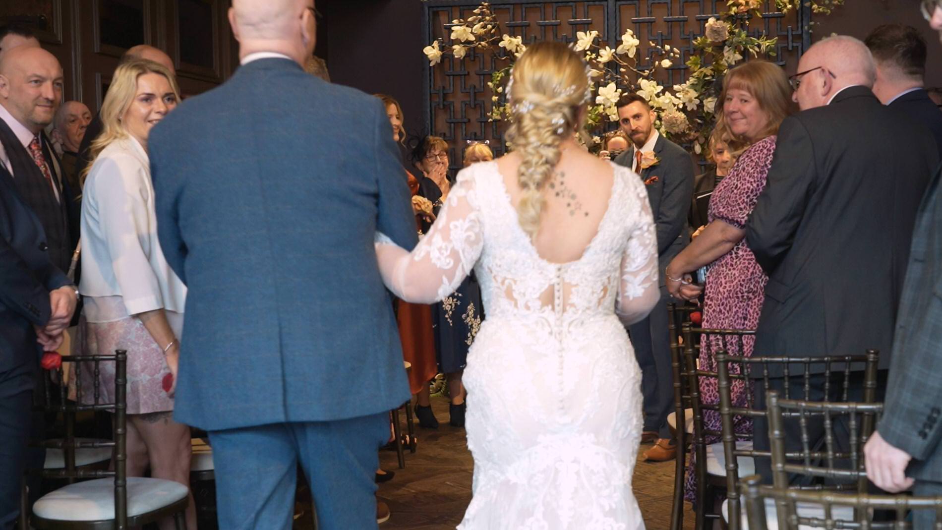 a bride walks down the aisle with her dad at Manor House Lindley Hudderfield