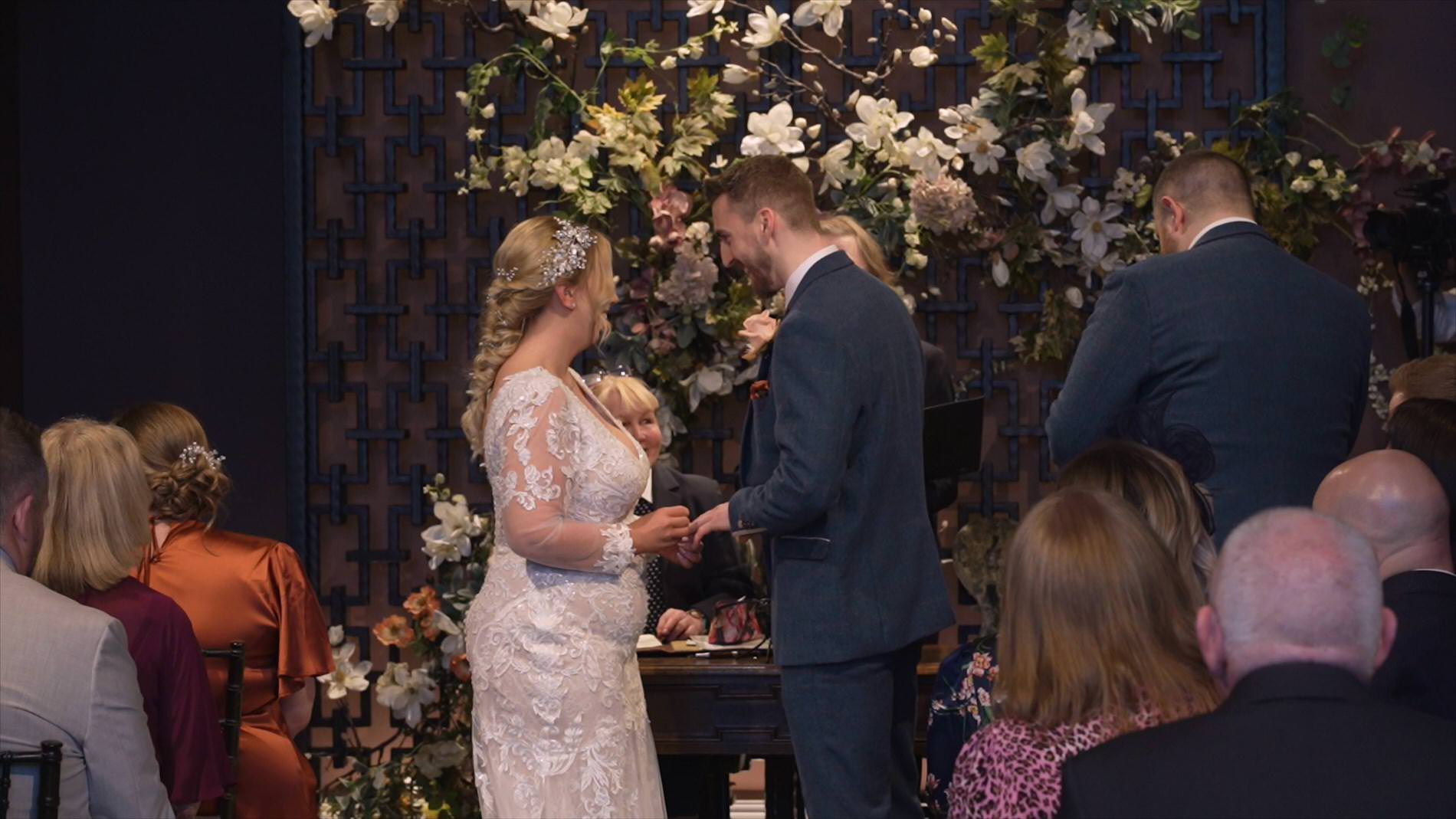 a couple exchange rings at ceremony in the Coach House at Manor House Lindley