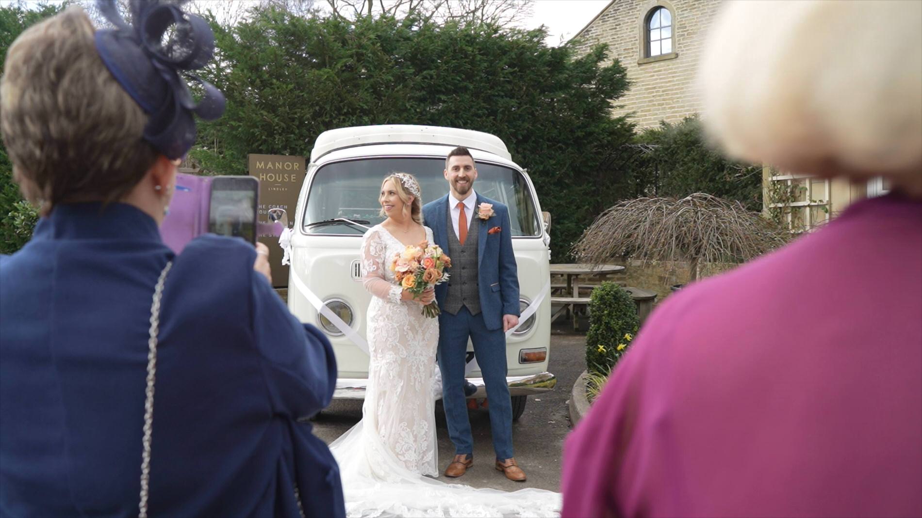 a natural moment of the couple posing for photos in front of a camper van at Manor House Lindley