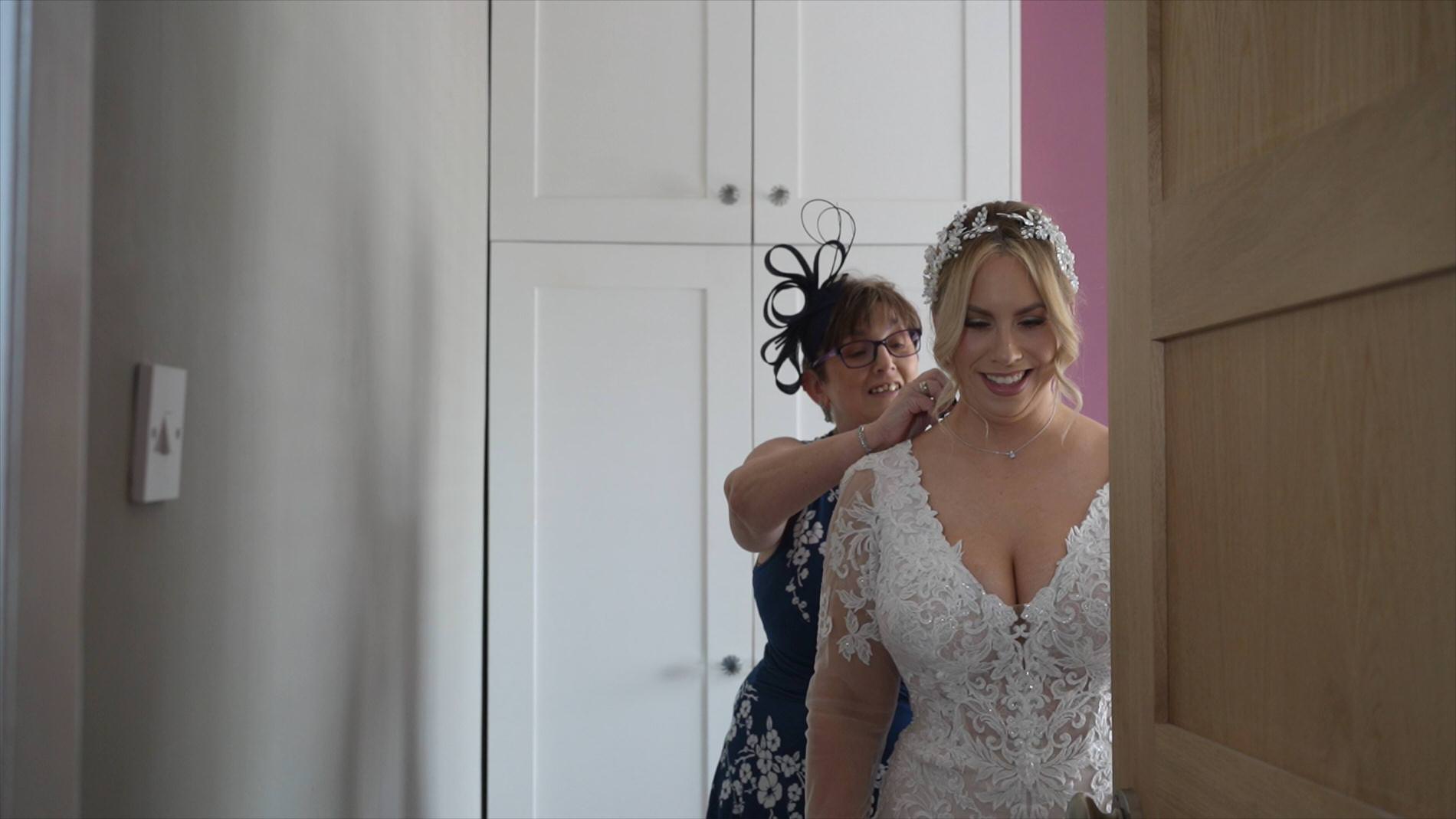 a mother of the bride helps with the jewellery