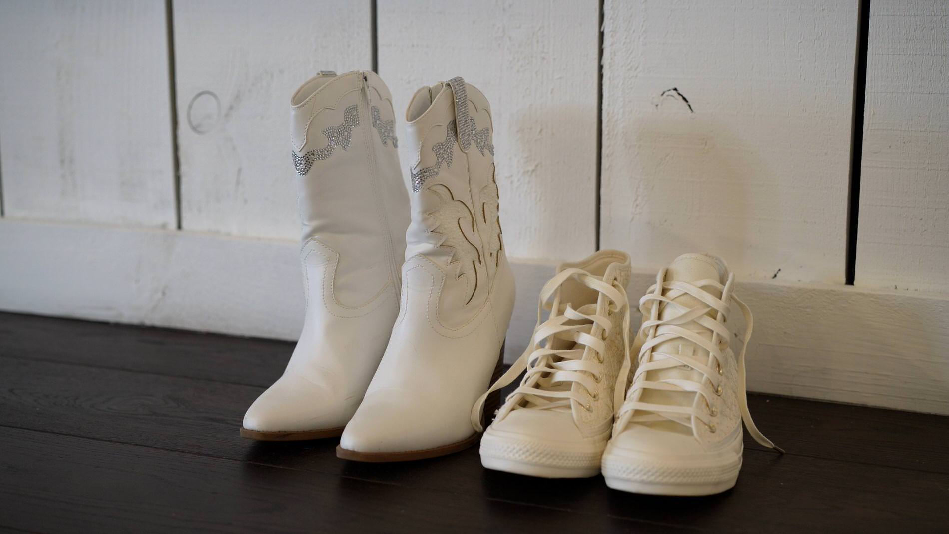 a pair of white bridal cowboy boots sit alongside converse